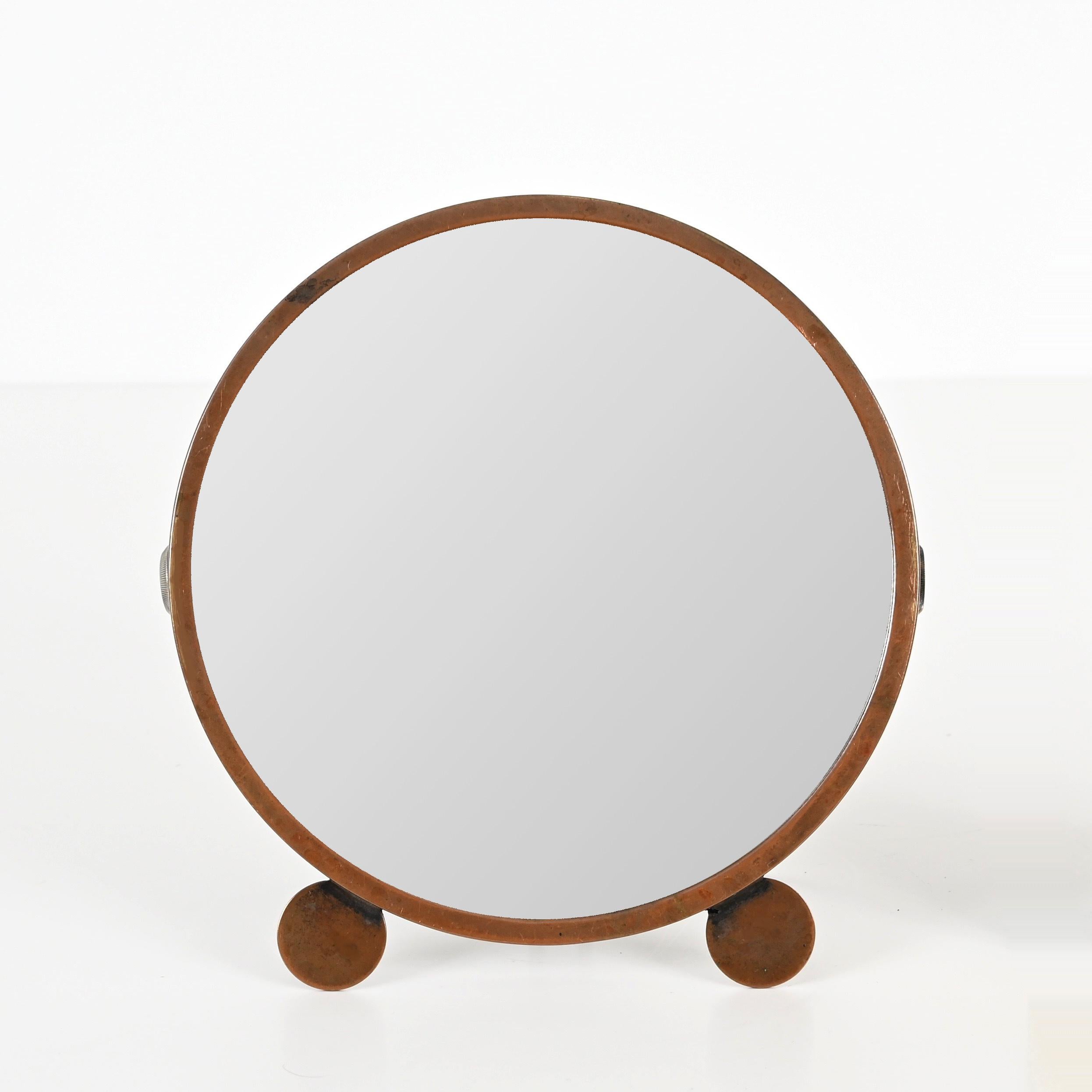 Amazing Art Deco adjustable table mirror in copper. This incredibly charming and unique piece was made in Italy during the 1930s.  

This table mirror has a round frame made in copper with a stunning bronzed even patina which enhances its charm and