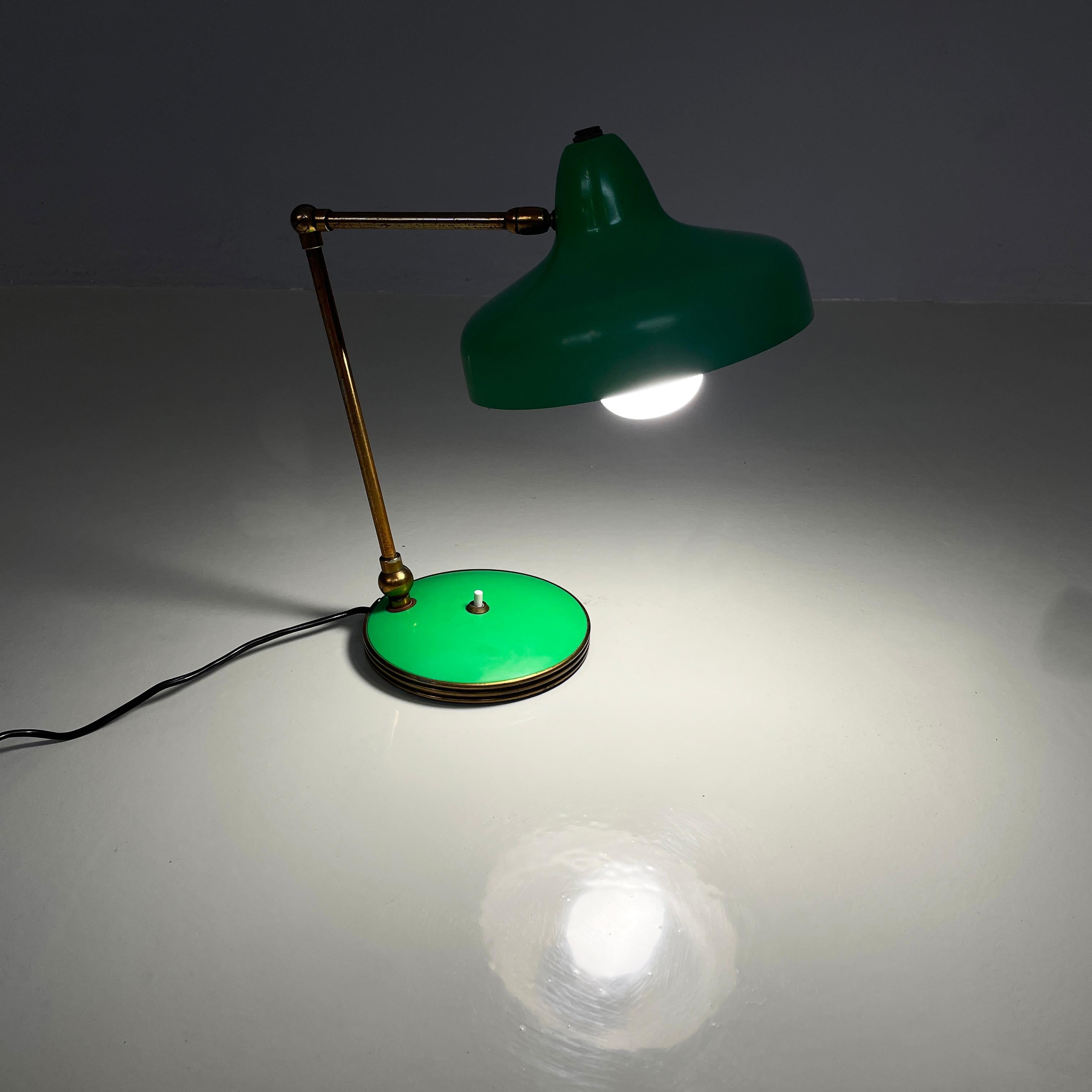 Lampe de table Art déco italienne réglable en laiton et métal vert, années 1950
Lampe de table réglable avec abat-jour à base ronde en métal peint en vert à l'extérieur. La structure est composée de deux bras ronds réglables en métal doré. La base