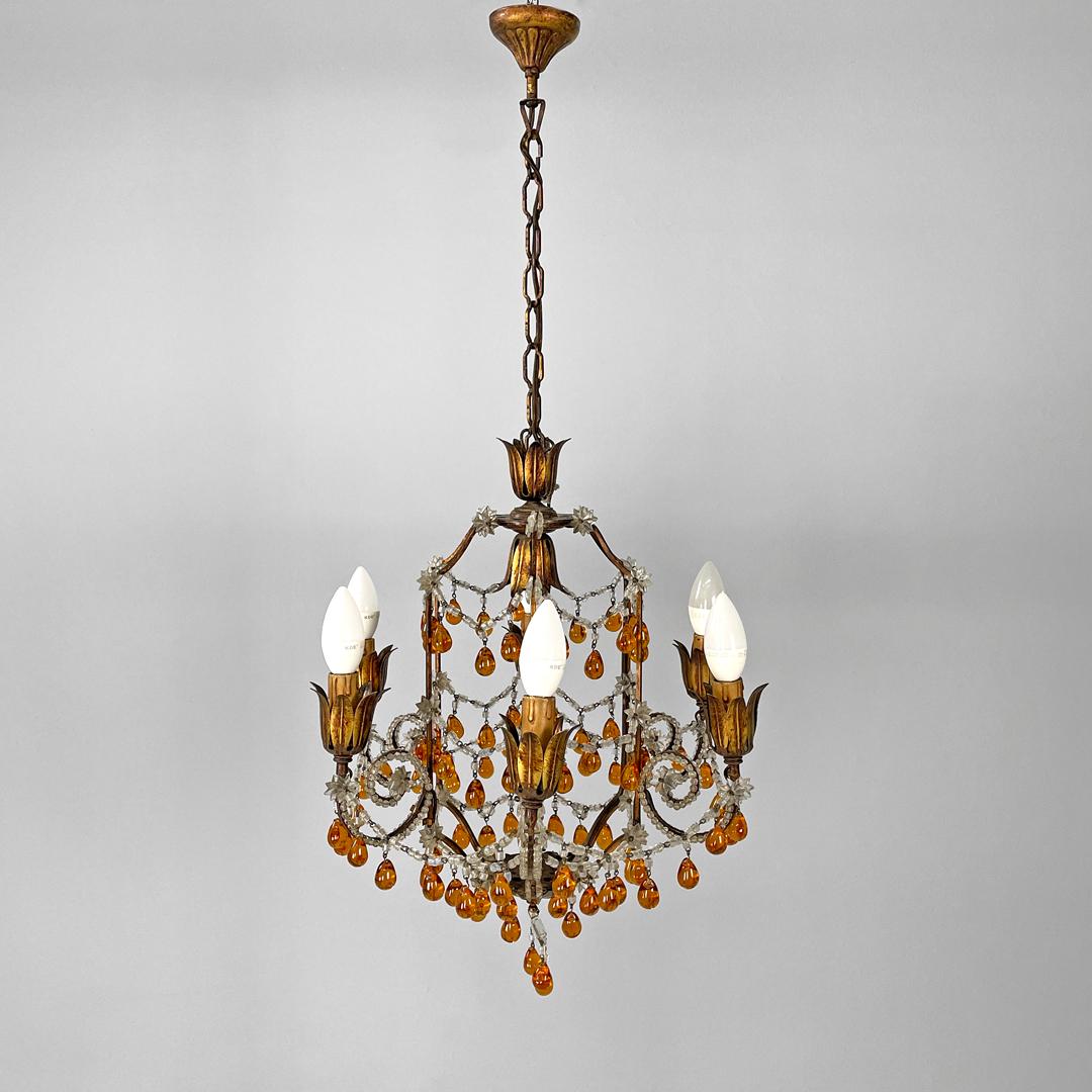 Italian Art Deco amber and clear glass drop chandelier in golden metal, 1930s
Round base chandelier. The structure is in gold painted metal, the central part is made up of six rods from which six arms develop that bend and curve upwards, ending with