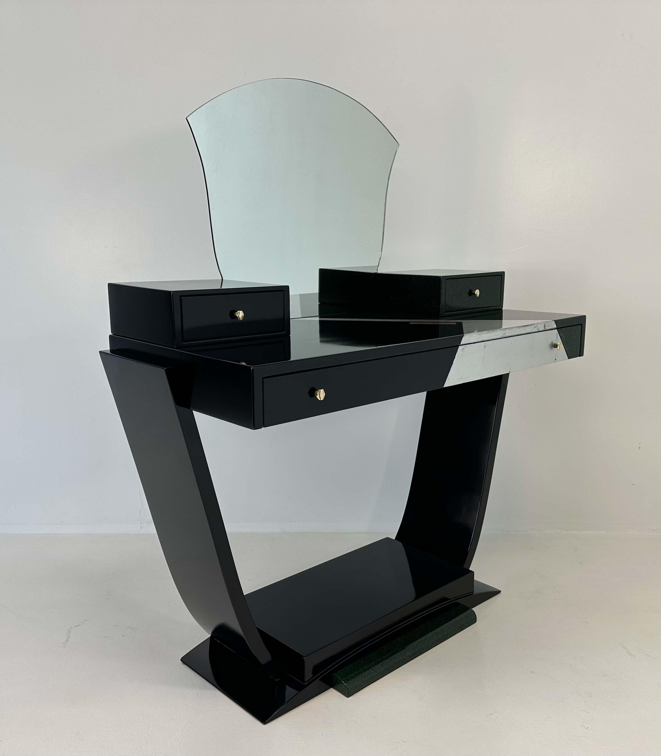 Table de toilette raffinée de style Art déco, fabriquée en Italie dans les années 1970.
La structure est en bois laqué, présentant une combinaison frappante de noir brillant et d'une finition laquée vert foncé particulière, enrichie d'élégantes