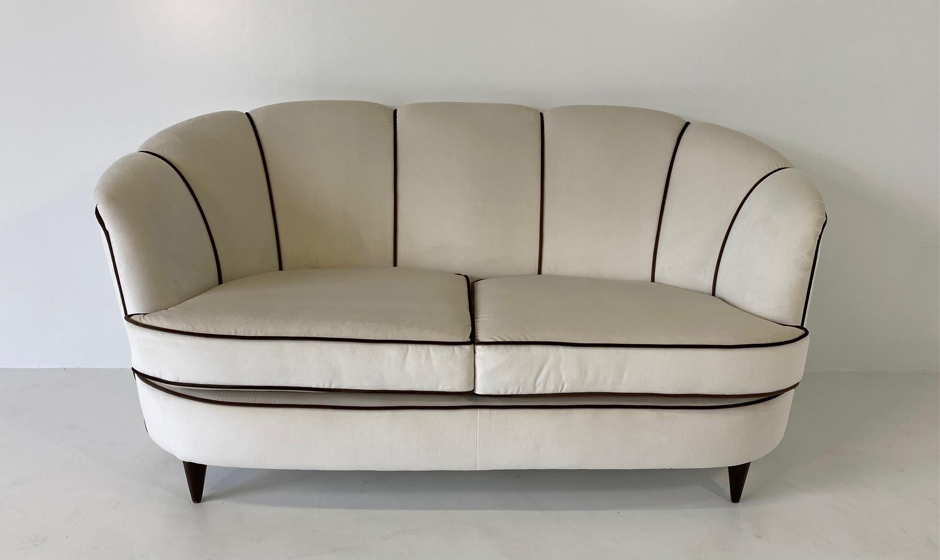 This Art Deco sofa was produced in Italy in the 1940s.

It has been completely restored and reupholstered with and elegant beige velvet and a profile made of brown velvet.