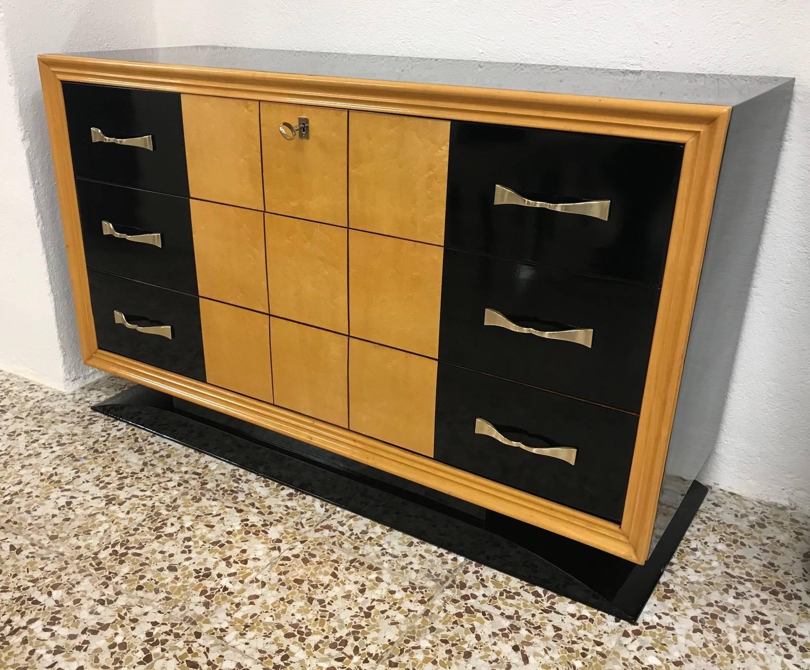 Fine Italian Art Deco dresser, drawers in black lacquer and maple.
The structure is made of black lacquered wood.
The elegant handles, the key and the nozzles are made of brass.