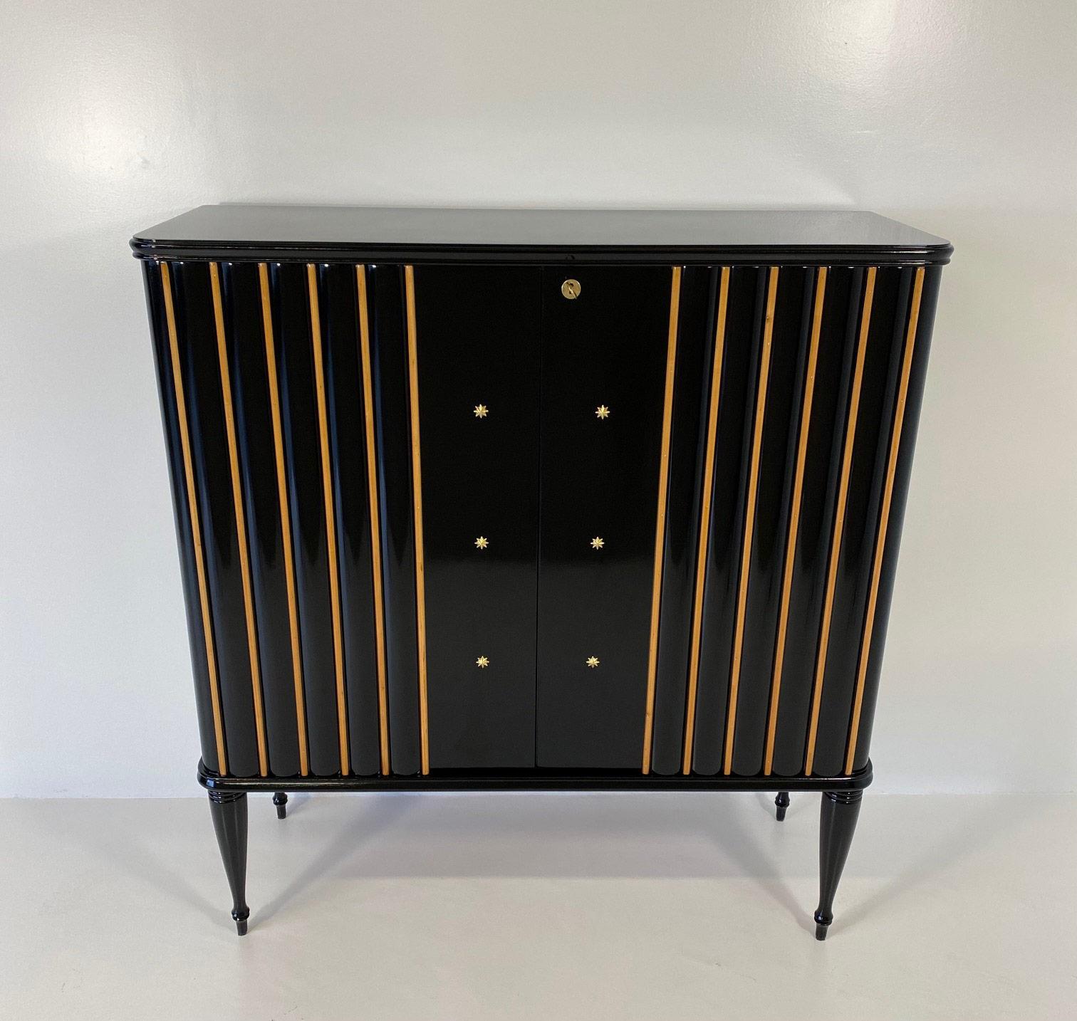 This elegant cabinet was produced in the north of Italy in the 1940s. 
It is completely black lacquered and enriched by fine brass decorations. 
The interiors are in maple. 
It has been completely restored in our laboratories.

 