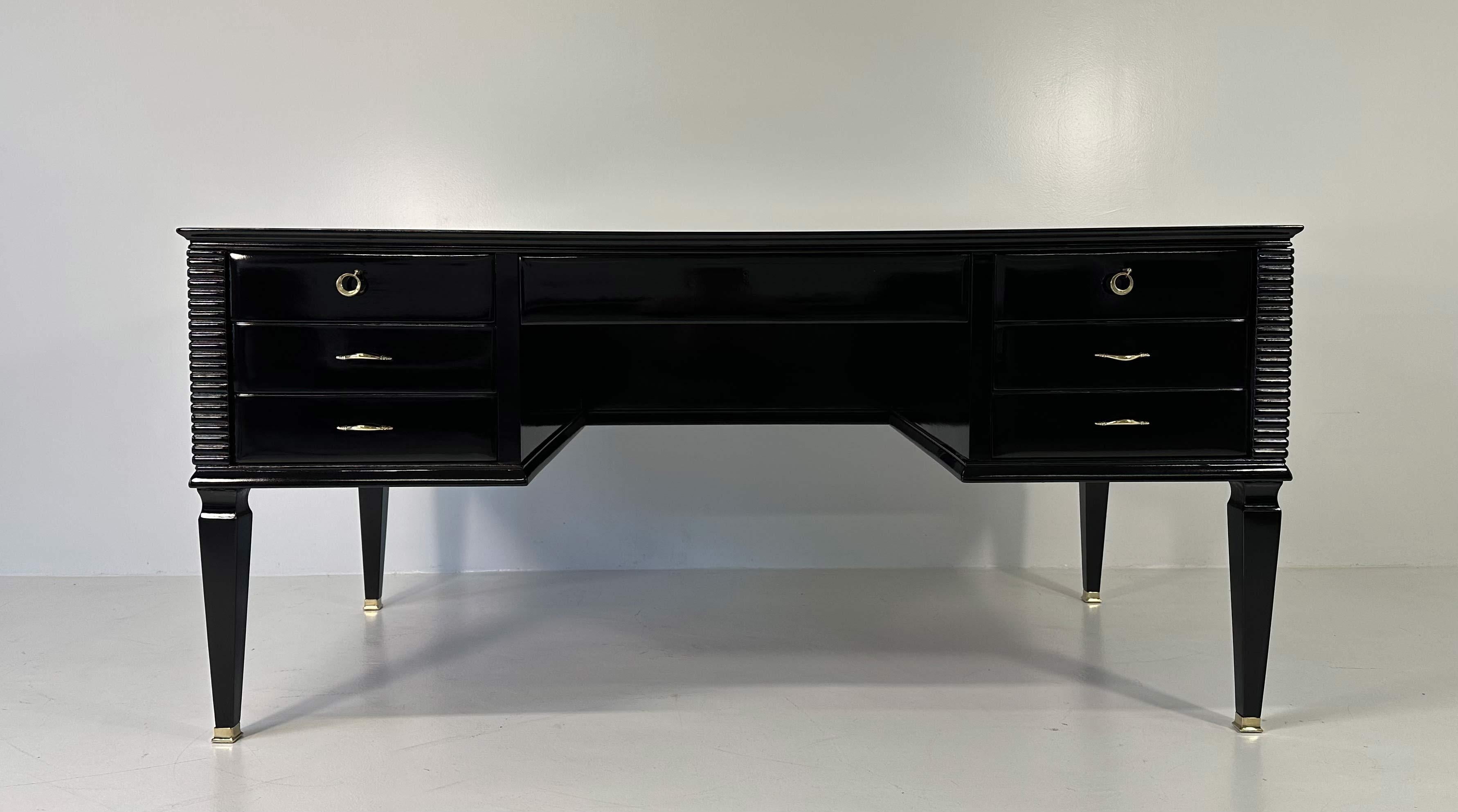 This Art Deco desk was produced in Italy in the 1950s, most likely on a design by Paolo Buffa.
It is entirely in black lacquered solid wood with brass keys, keyholes, handles and tips.
Original black colored glass top.
Completely restored.