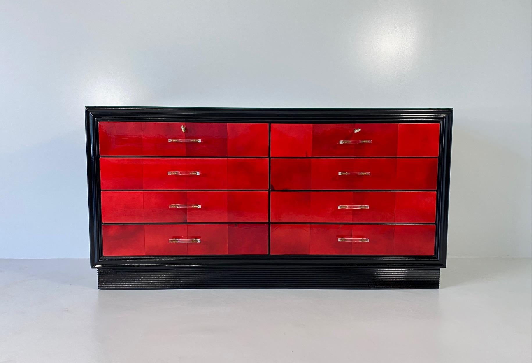 This Art Deco dresser was produced in Italy in the 1950s circa. 
The structure is black lacquered while the drawers are covered in cherry/red parchment squares.
The handles are made copper and plexiglass. 
Completely restored. 

 