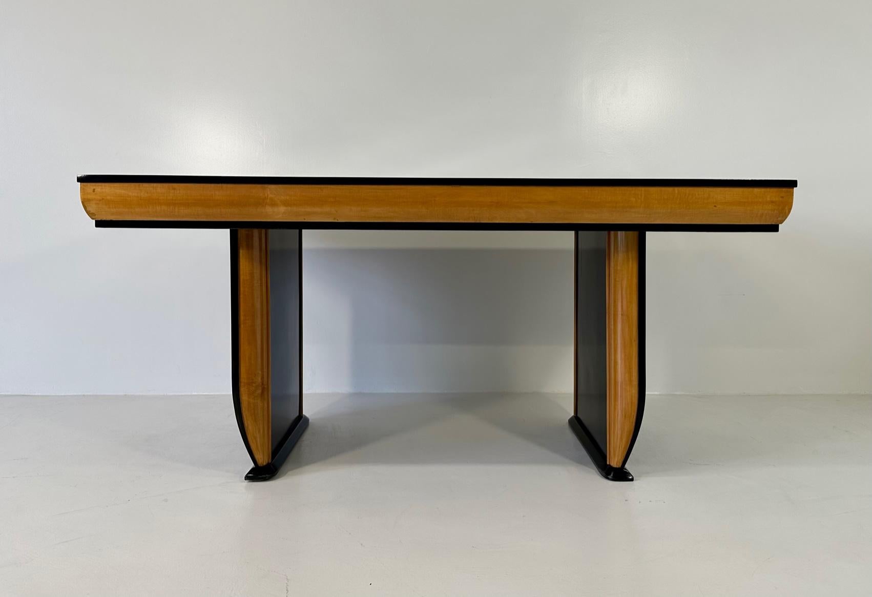 This beautiful table was produced in Italy in the 1940s and is attributable to the  famous Italian designer Osvaldo Borsani. 
The top, the profiles and the legs are black lacquered, while the profiles of the top and of the legs are in elegant maple.