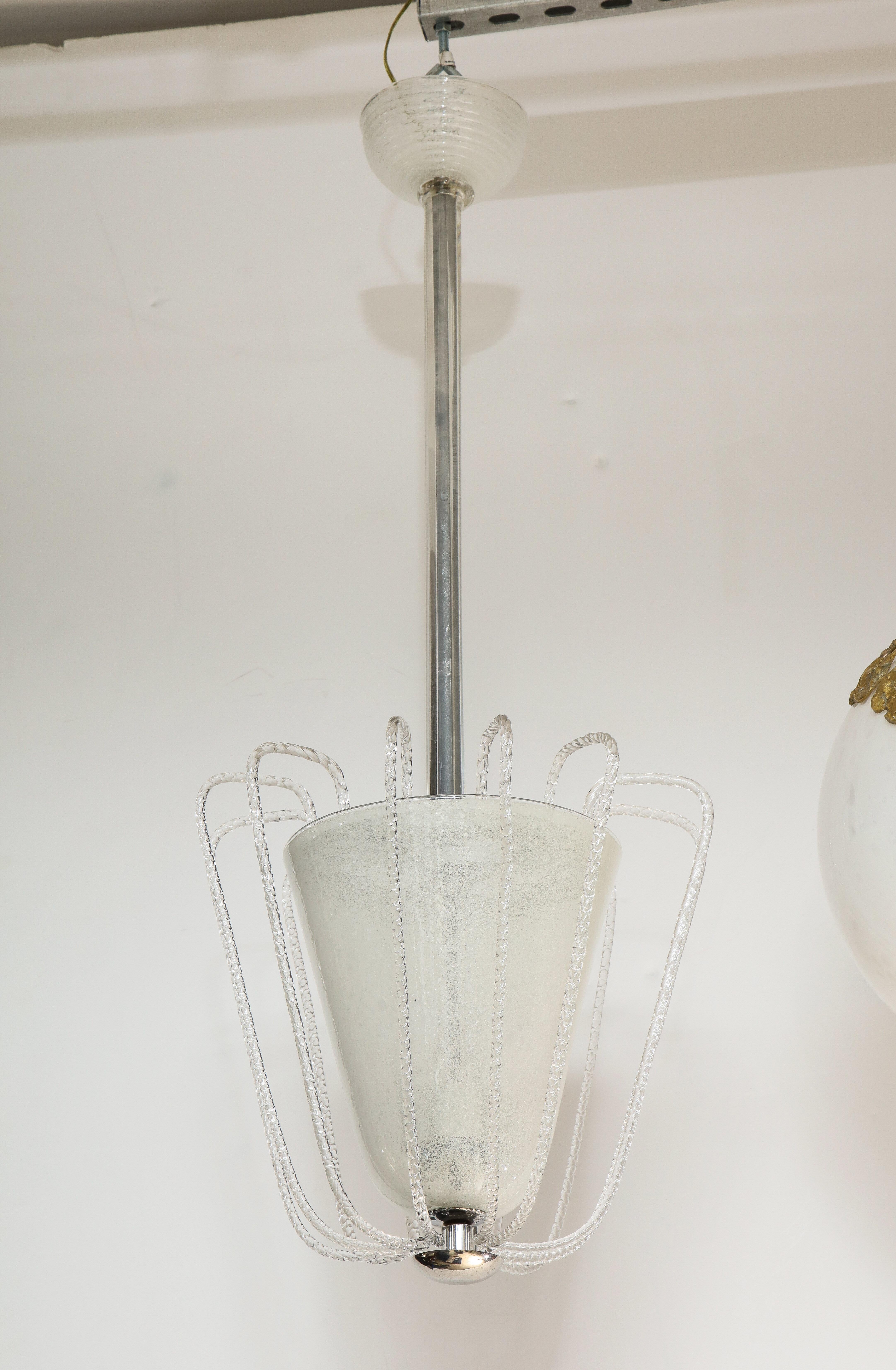 An Italian Art Deco 'fountain' 1930s chandelier, the body with frosted glass surrounded by turned glass spindles creating a waterfall effect, the supporting finial in plated nickel and the central stem and canopy in turned blown glass. Exquisitely