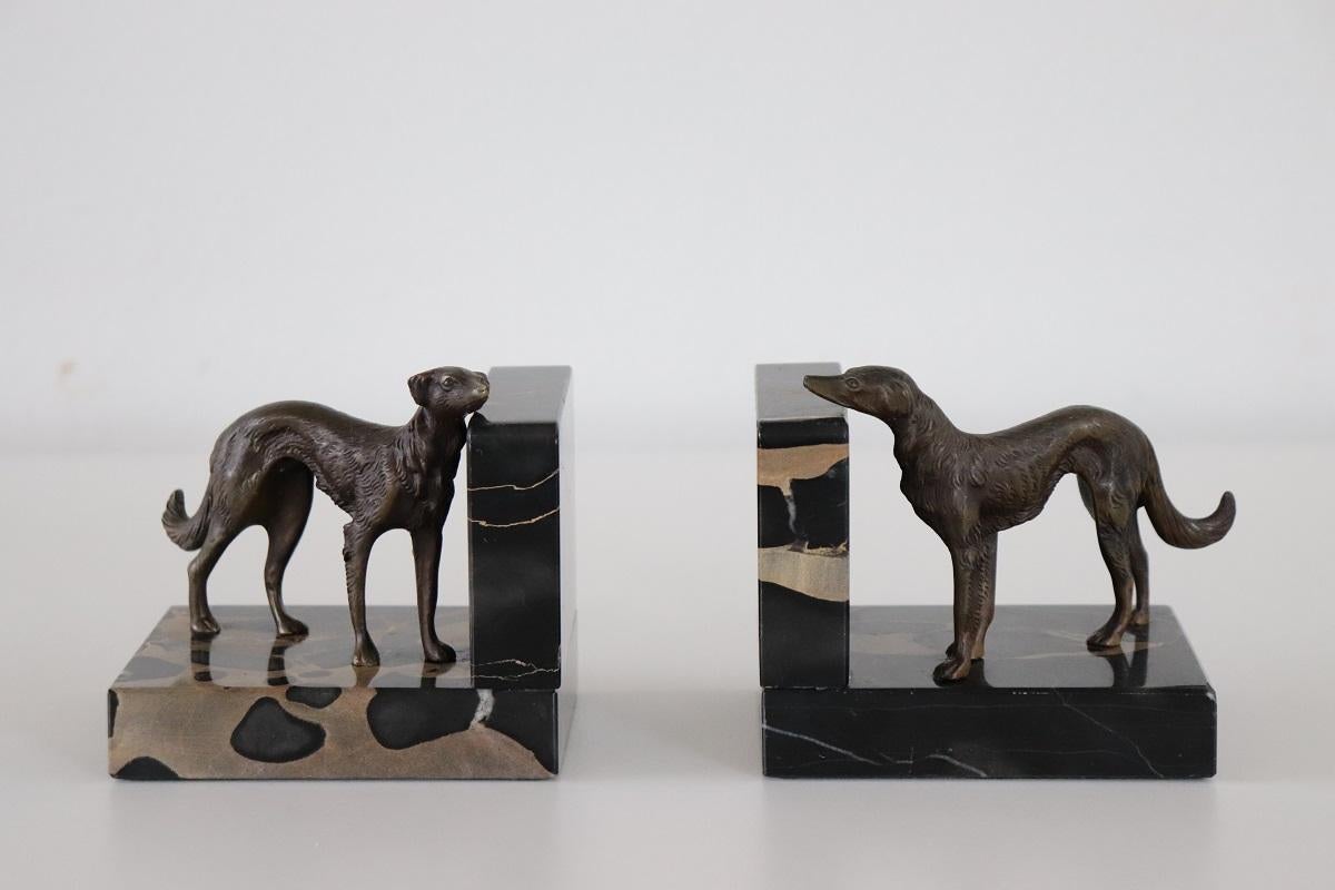 This rare pair of bookends from the Italian Art Deco period is truly refined. Two greyhound dogs in patinated bronze assuming two different poses on a base of fine black Italian marble. This type of black marble is very rare, called Portoro marble,