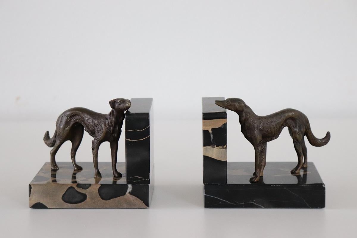 This rare pair of bookends from the Italian Art Deco period is truly refined. Two greyhound dogs in patinated bronze assuming two different poses on a base of fine black Italian marble. This type of black marble is very rare, called Portoro marble,