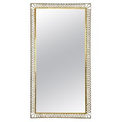 Italian Art Deco Brass wall mirror with swirl decorated frame and glass, 1940s