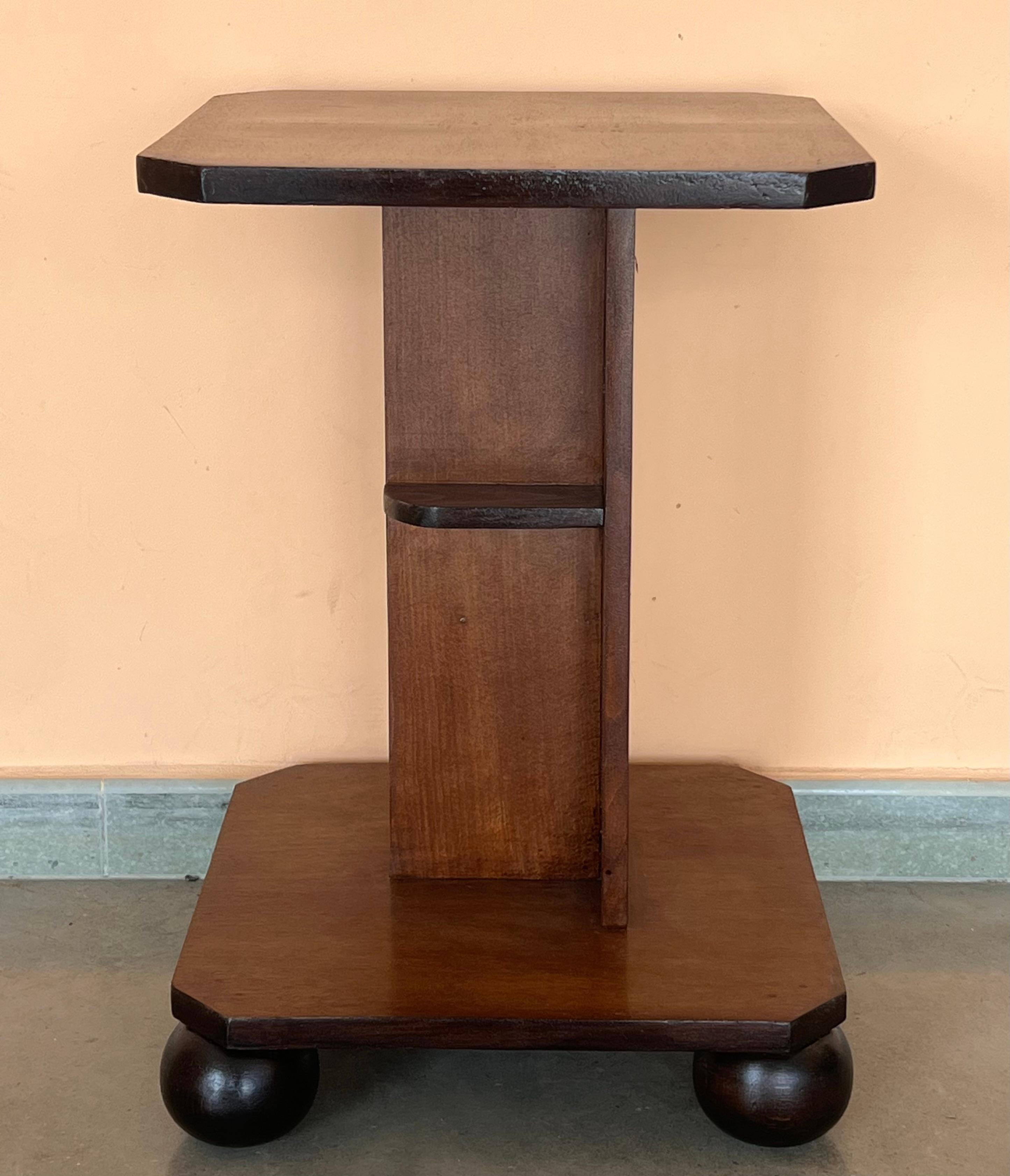 Italian Art Deco octogonal side table, circa 1930s. Narrow ebonized feet and round finial at center base set off the figured walnut. Lower smaller round tier. Unknown maker