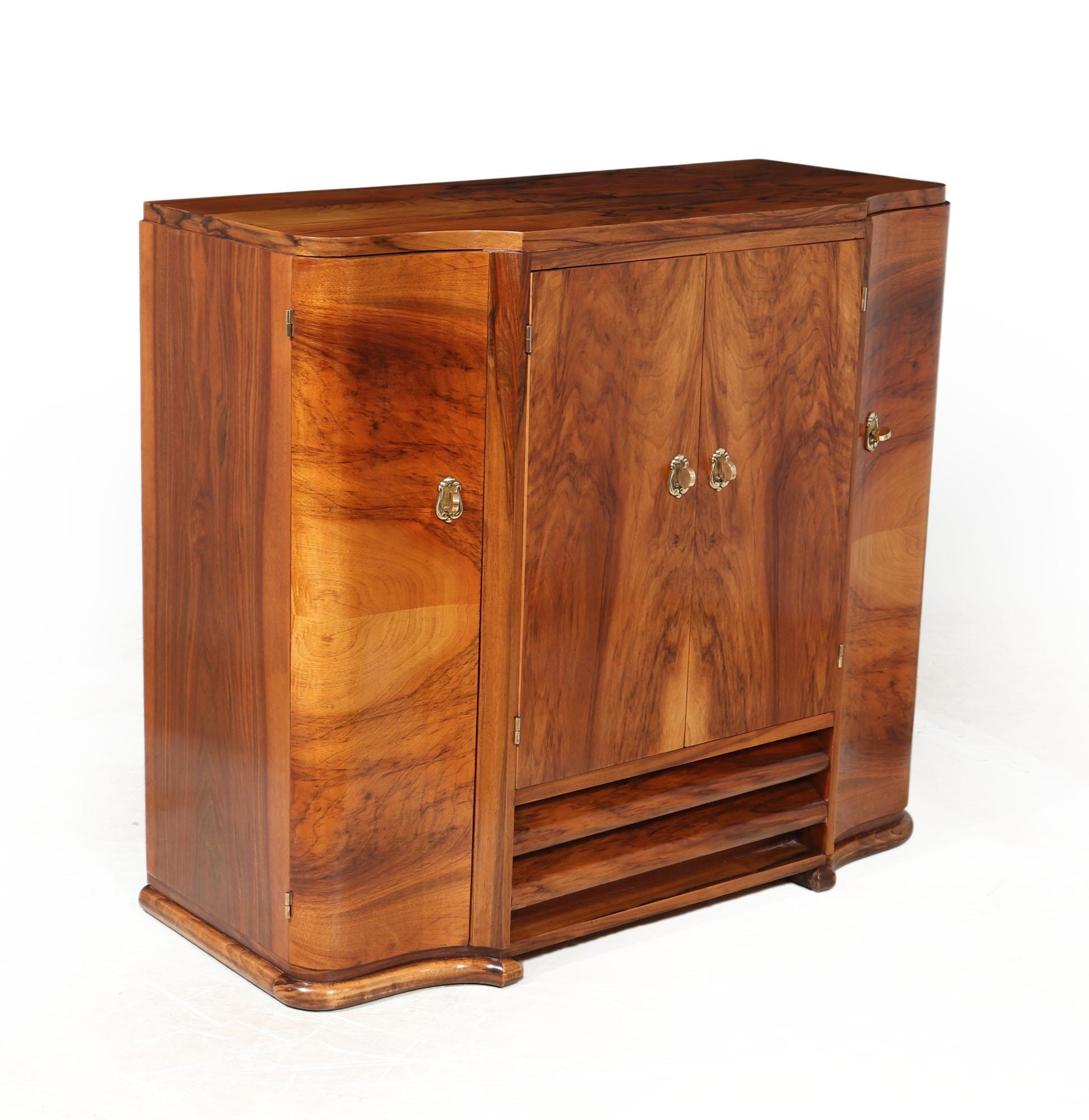ITALIAN ART DECO CABINET IN WALNUT
A small Art Deco sideboard or buffet produced in walnut in the 1930’s in Italy, the cabinet has a serpentine shaped front and four doors with shelves behind and brass handles, the sideboard has been carefully