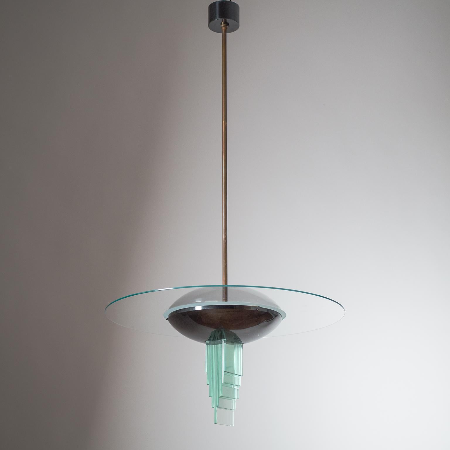 Sculptural Italian Art Deco chandelier from the 1930s - a design that has been attributed to Gio Ponti and Pietro Chiesa. Dark patinated copper hardware with a multi-tiered glass centerpiece and a large glass disc on top. Three original brass and