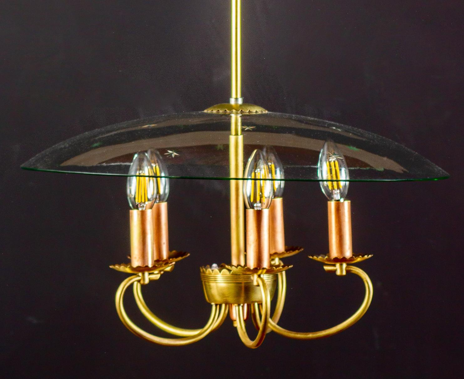 Delicious Art Deco chandelier with scrolled brass terminating in five scallop edged flower form socket cups, supported by finely etched glass. Attributed to Pietro Chiesa style for Fontana Arte.
Excellent original vintage condition.
Length of drop