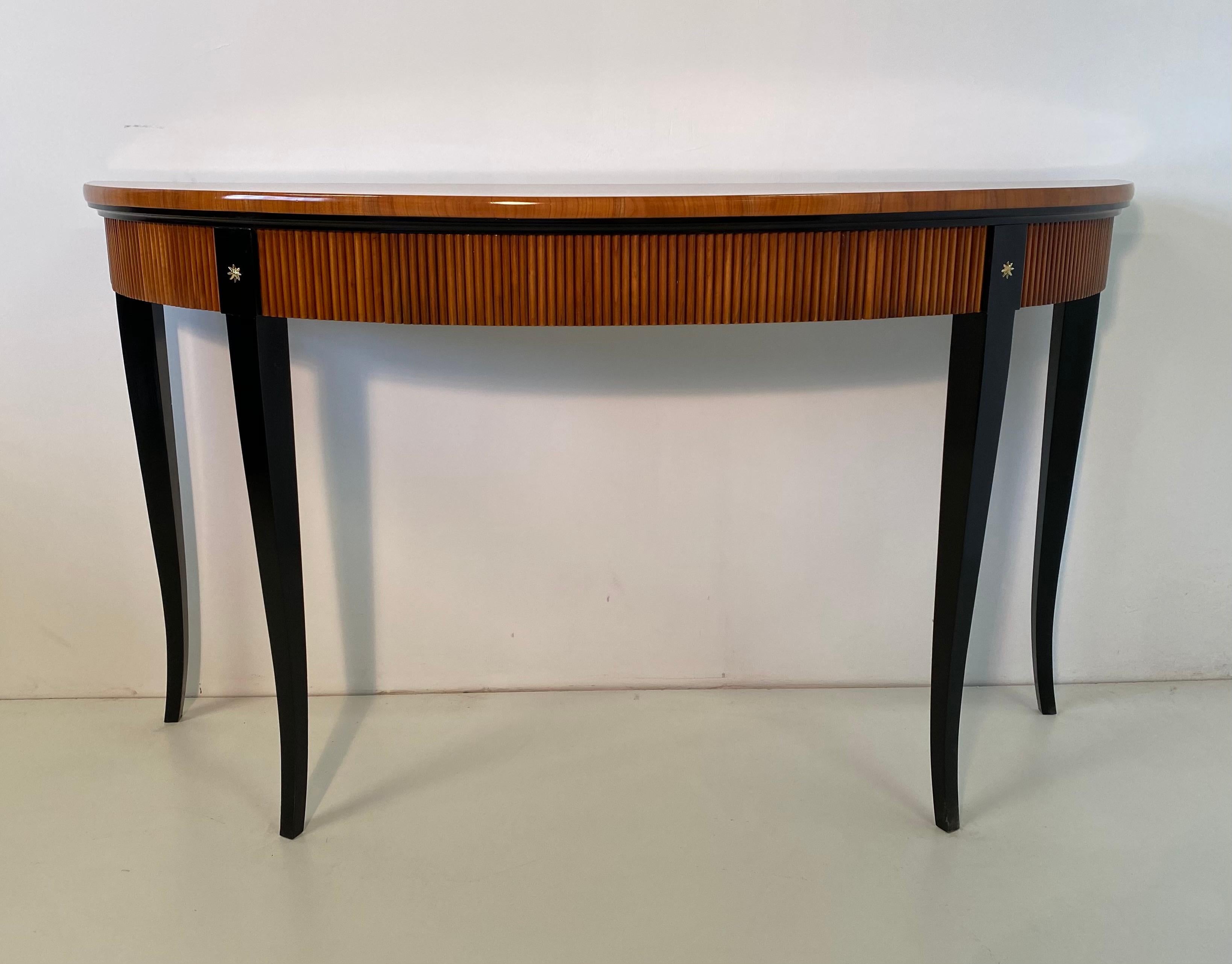 Elegant Art Deco console from the 1950s produced in Italy entirely in cherrywood with black lacquer details.
It has a drawer and it is embellished with two brass stars.
Totally restored.