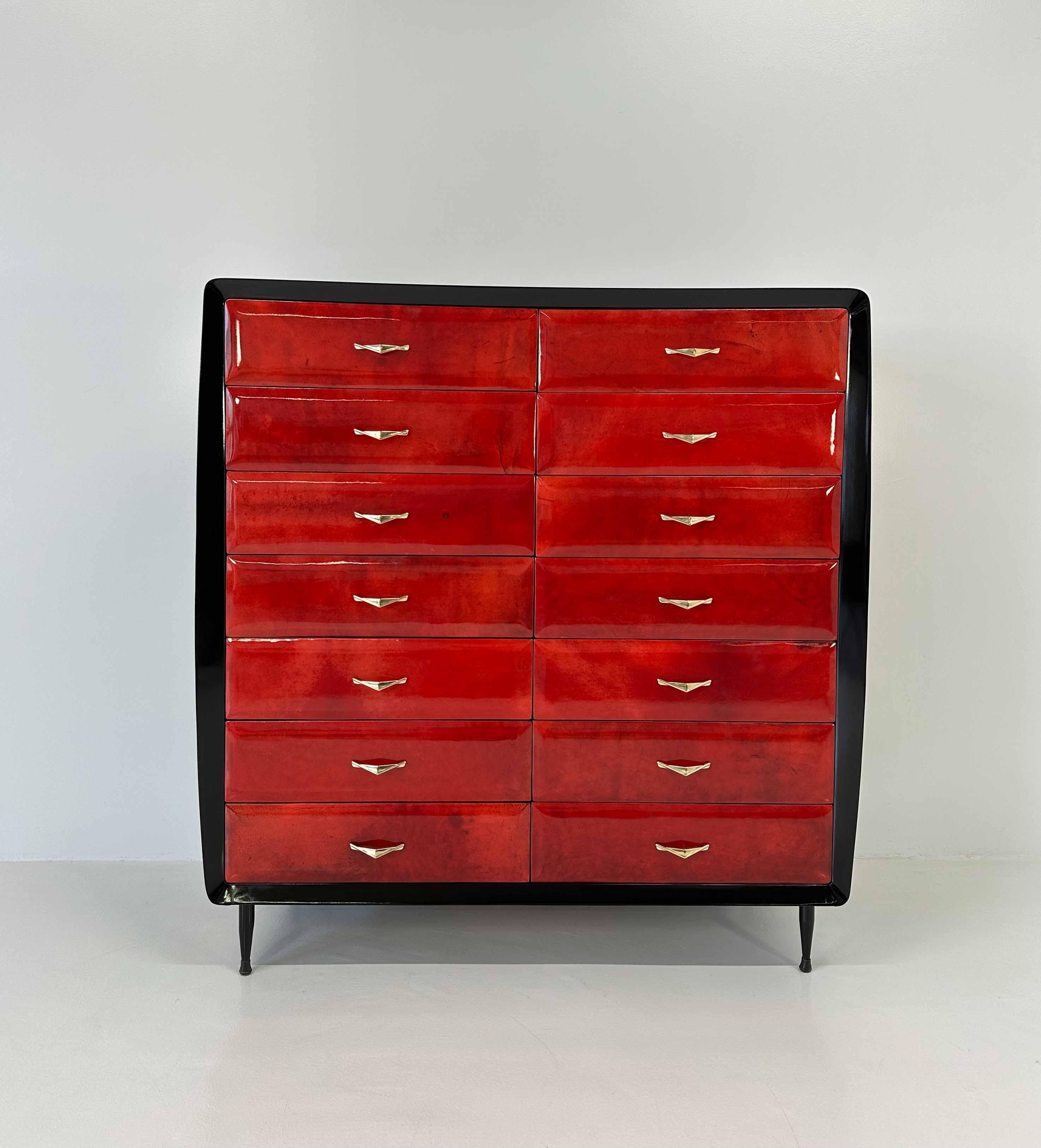 This Art Deco chest of drawers was produced in Italy in the 1950s. 
The structure is in black lacquer, while the 14 drawers are covered with cherry red parchment.
The top is in black glass and the handles are in brass. 
Completely restored. 
