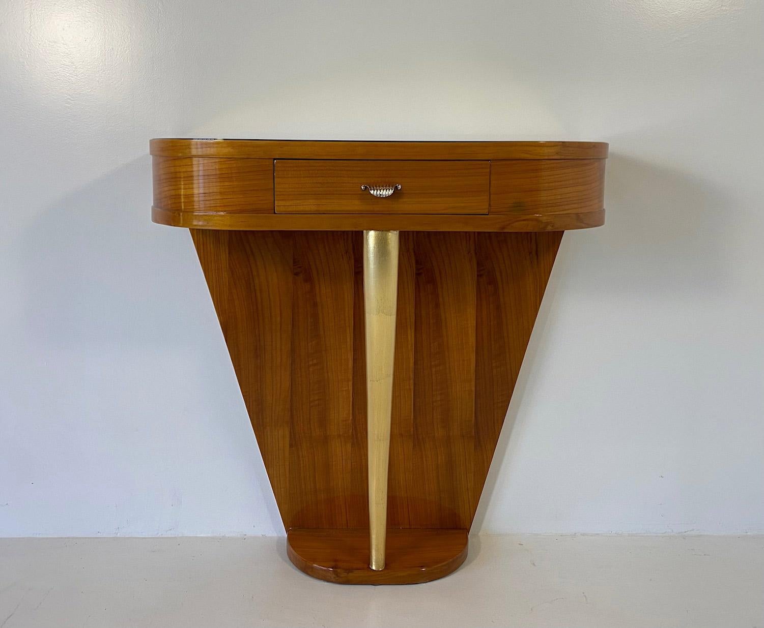 This elegant console was produced in Italy in the 1940s, with a style and a design that clearly remind the creations of the Italian designer Paolo Buffa.   The console is completely made of Cherry wood, the exceptions are the top, which is a good