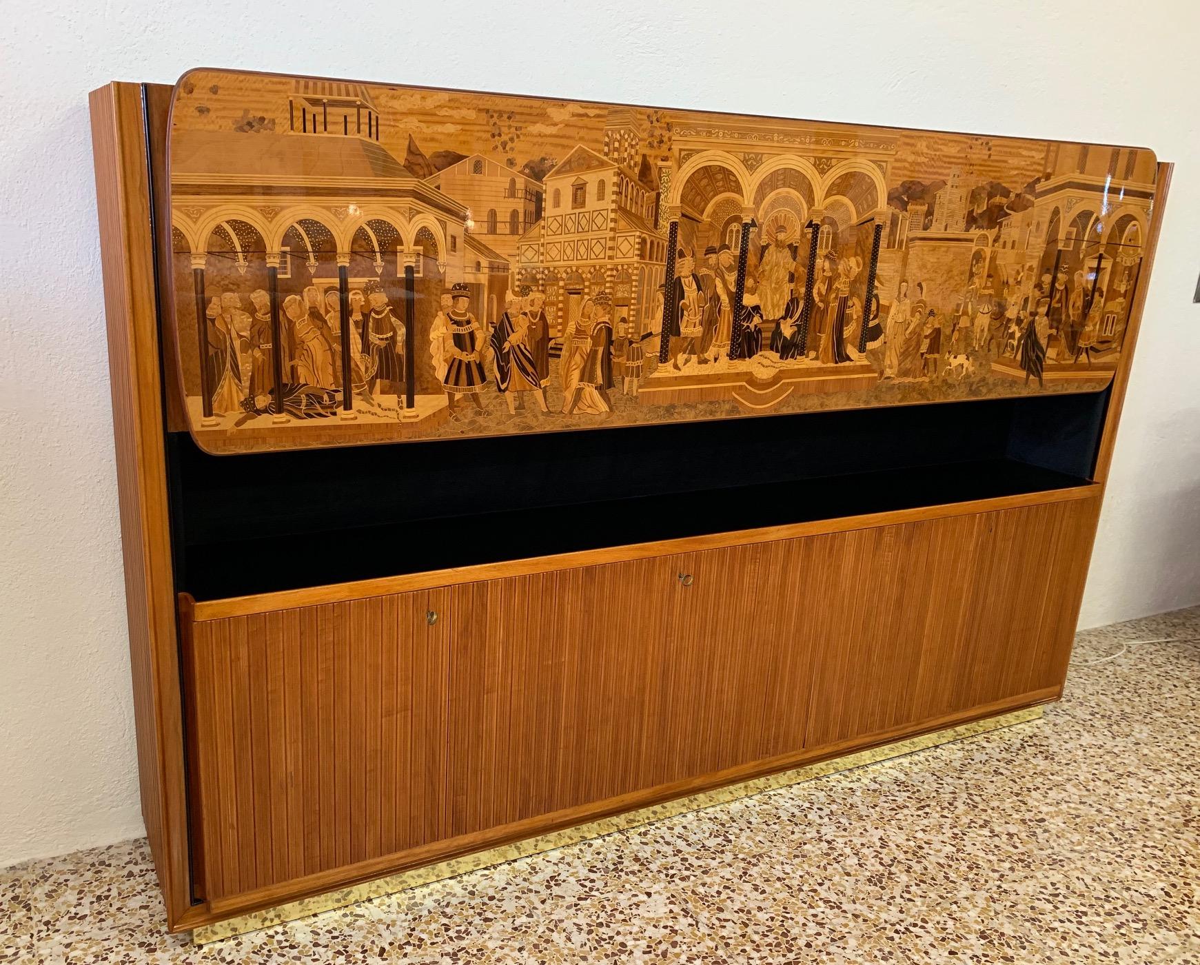 This item was produced in the 1940s in Italy by Vittorio Dassi for the ' Permanente Mobili Cantù'.
The cabinet is completely made of cherrywood with black lacquered profiles.
The large central door has a beautiful inlay with innumerable essence