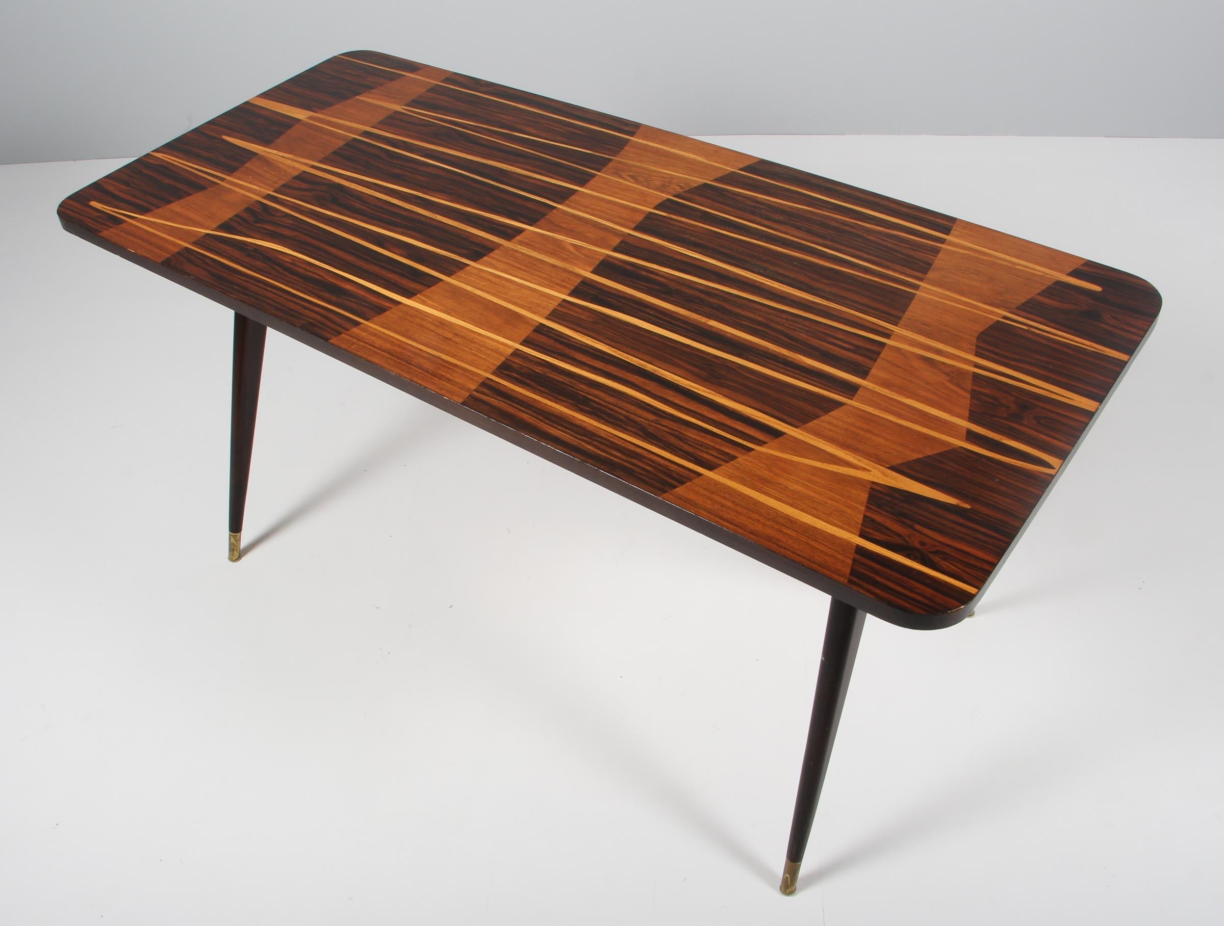 Art Deco Italian coffee table with plate of rosewood, with intarsia work. Legs with brass feet. 

Probably made in the 1960s.