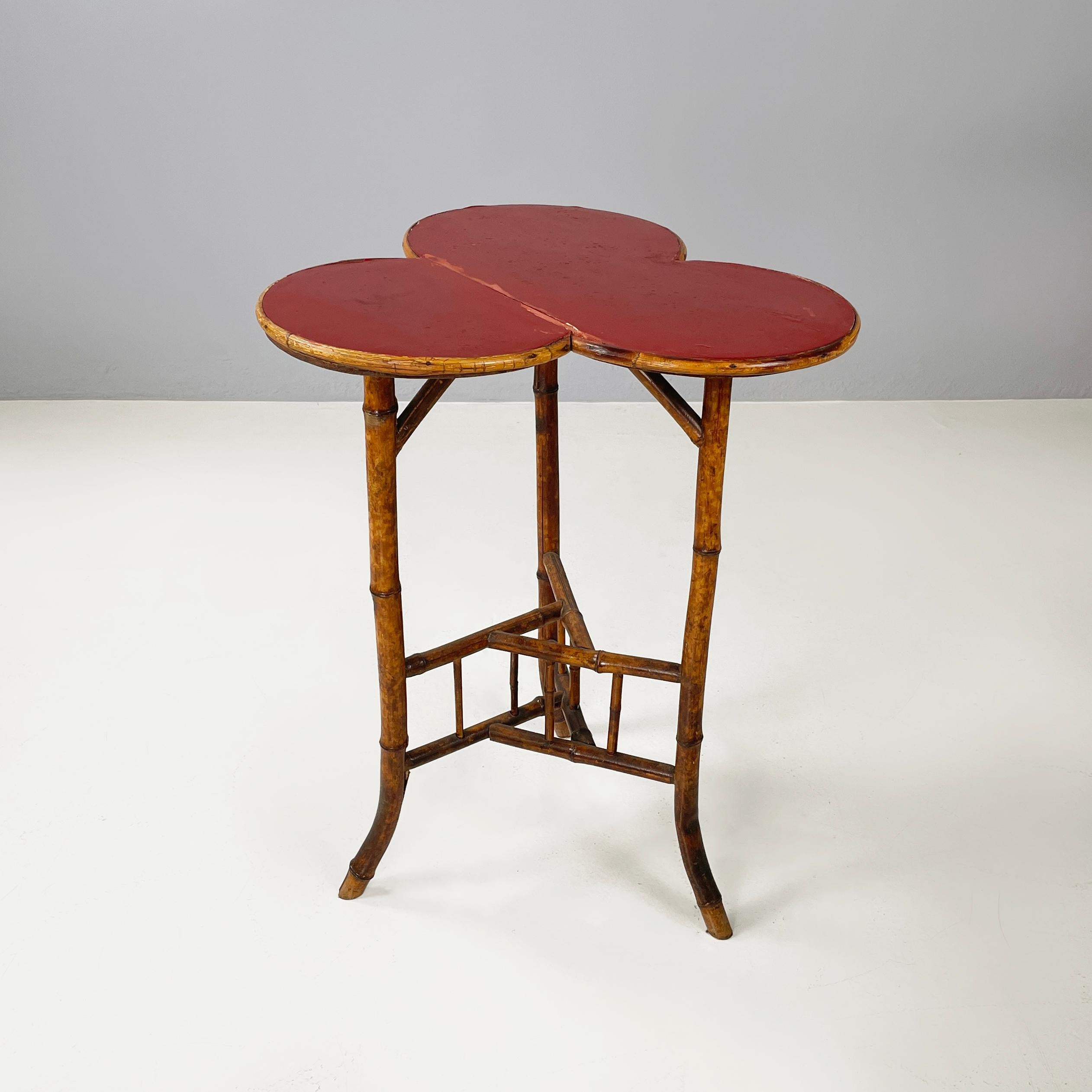 Italian art deco Coffee table with red wood clover top and bamboo, 1900-1950s
Coffee table with clover-shaped top in dark red painted wood with wooden profile. The three bamboo legs have a triangular structure in the center, also made of bamboo.