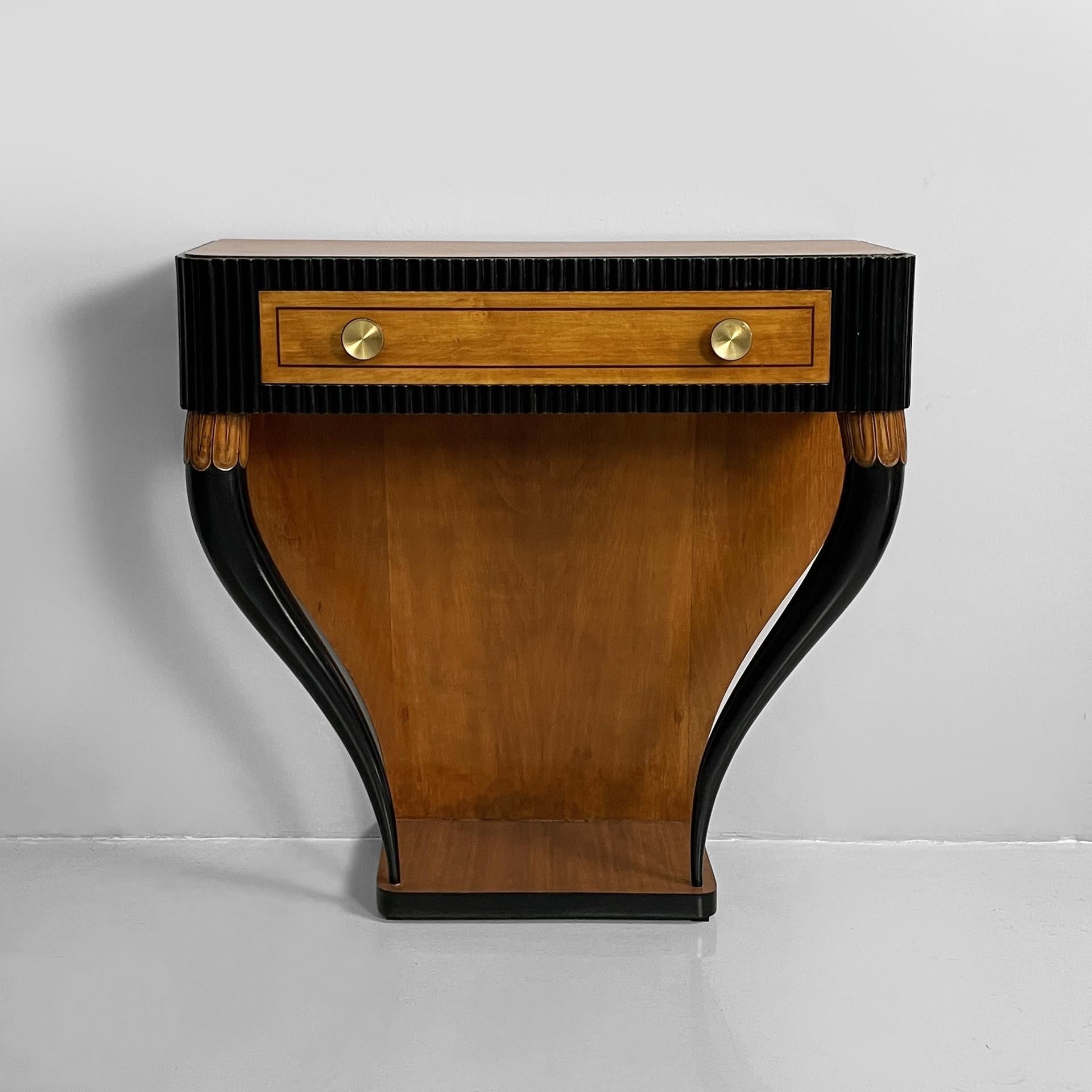 Italian Art Deco console in grissinato black wood, 1930s
Wall-mounted console table with a rectangular top and rounded corners, made of wood. The black grissinato wood front features a rectangular wooden drawer with round brass handles. The
