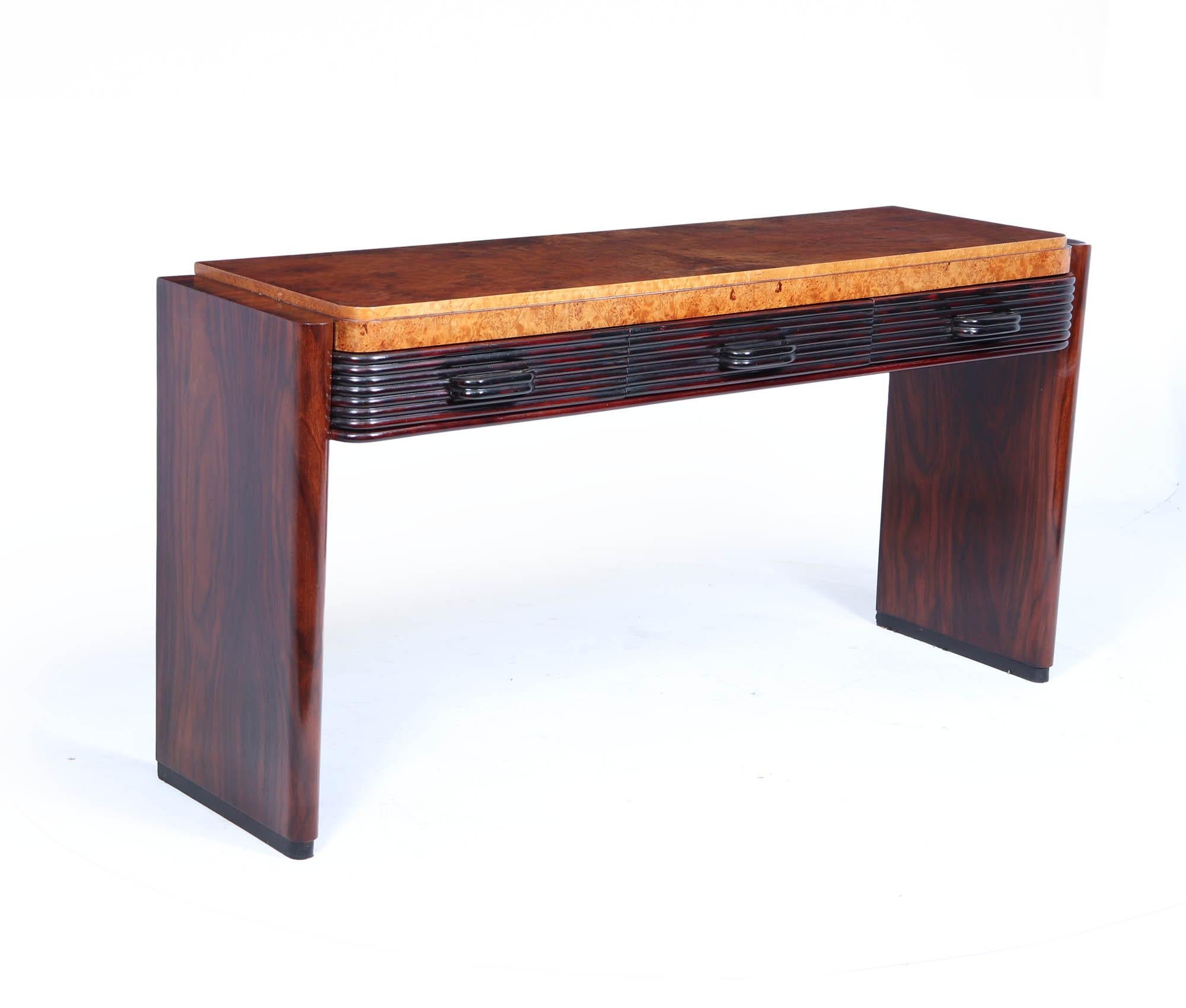 Italian Art Deco Console Table
An Art Deco console table produced in Italy in the 1930’s having rosewood legs and burr maple top with three reeded drawers and handles carefully restored and professionally polished by hand and in excellent condition