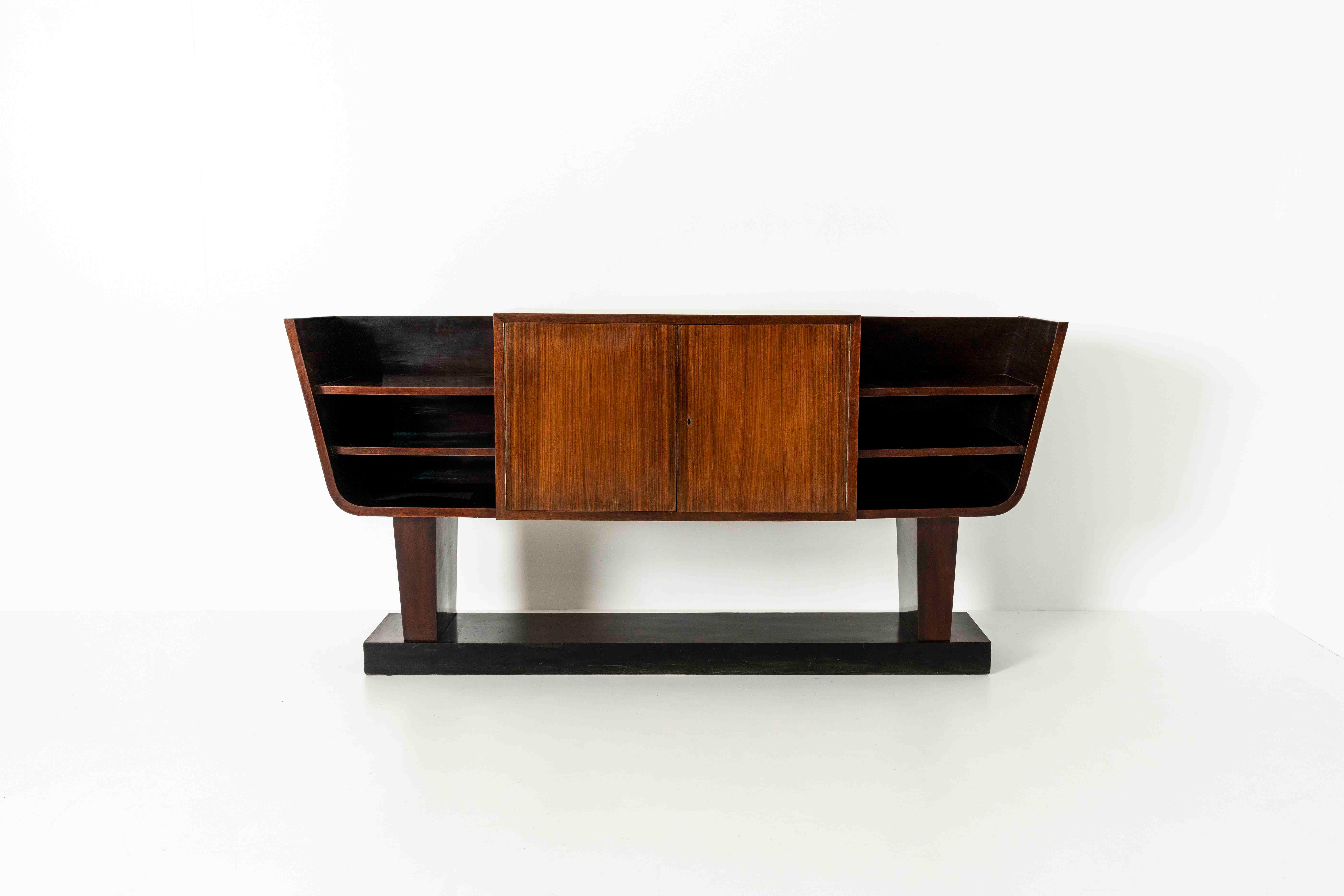 Impressive and large Italian Art Deco Credenza. This unique piece is a mix between a credenza and a console. It features two doors in the middle leading to a shelve that is open on both sides. Highly decorative, yet functional. We especially love