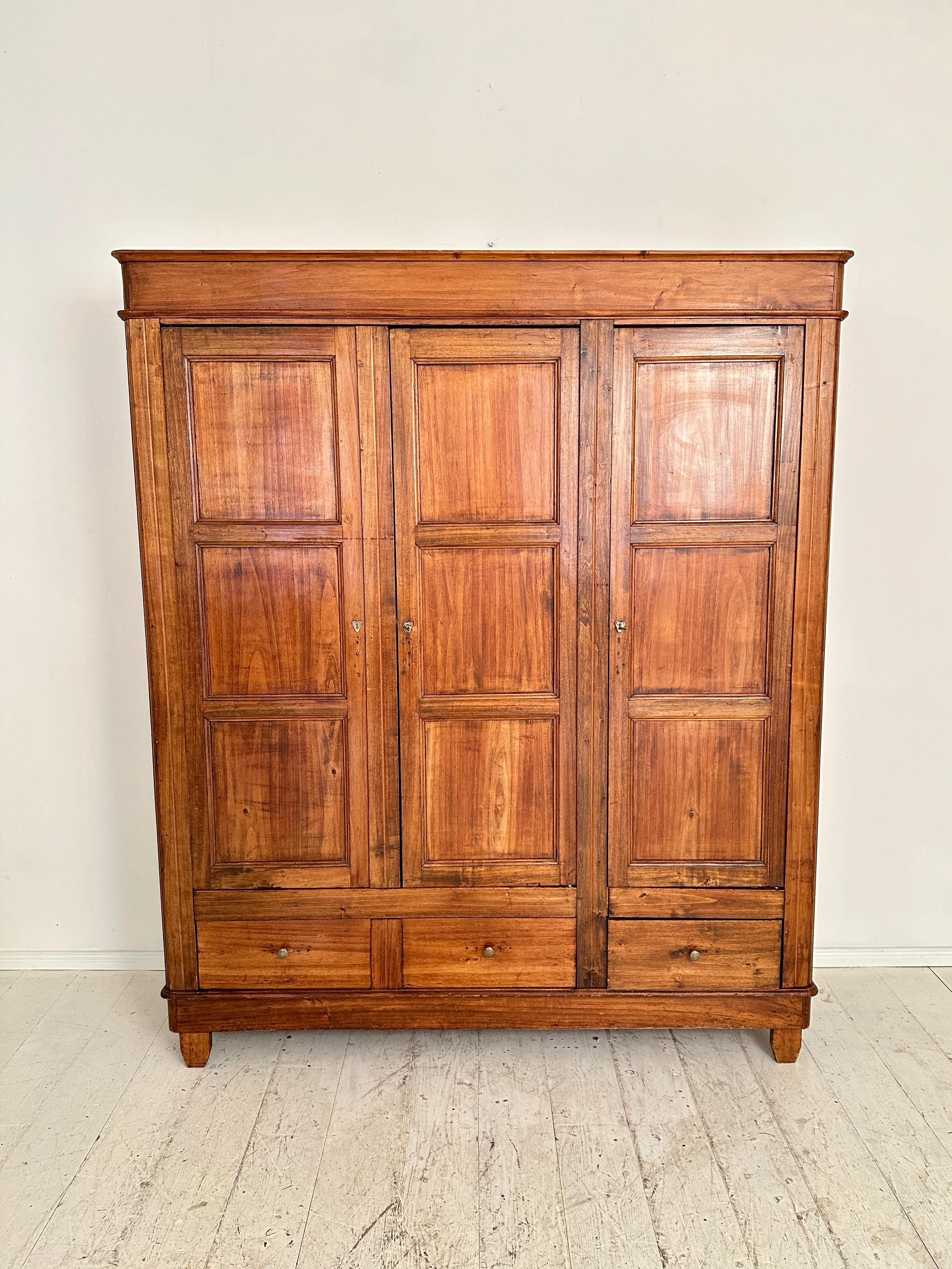 This exquisite Italian Art Deco cupboard, crafted around 1920, stands as a testament to timeless elegance and masterful craftsmanship. Fashioned from rich brown wood, it exudes warmth and sophistication. 
The meticulous design features three doors