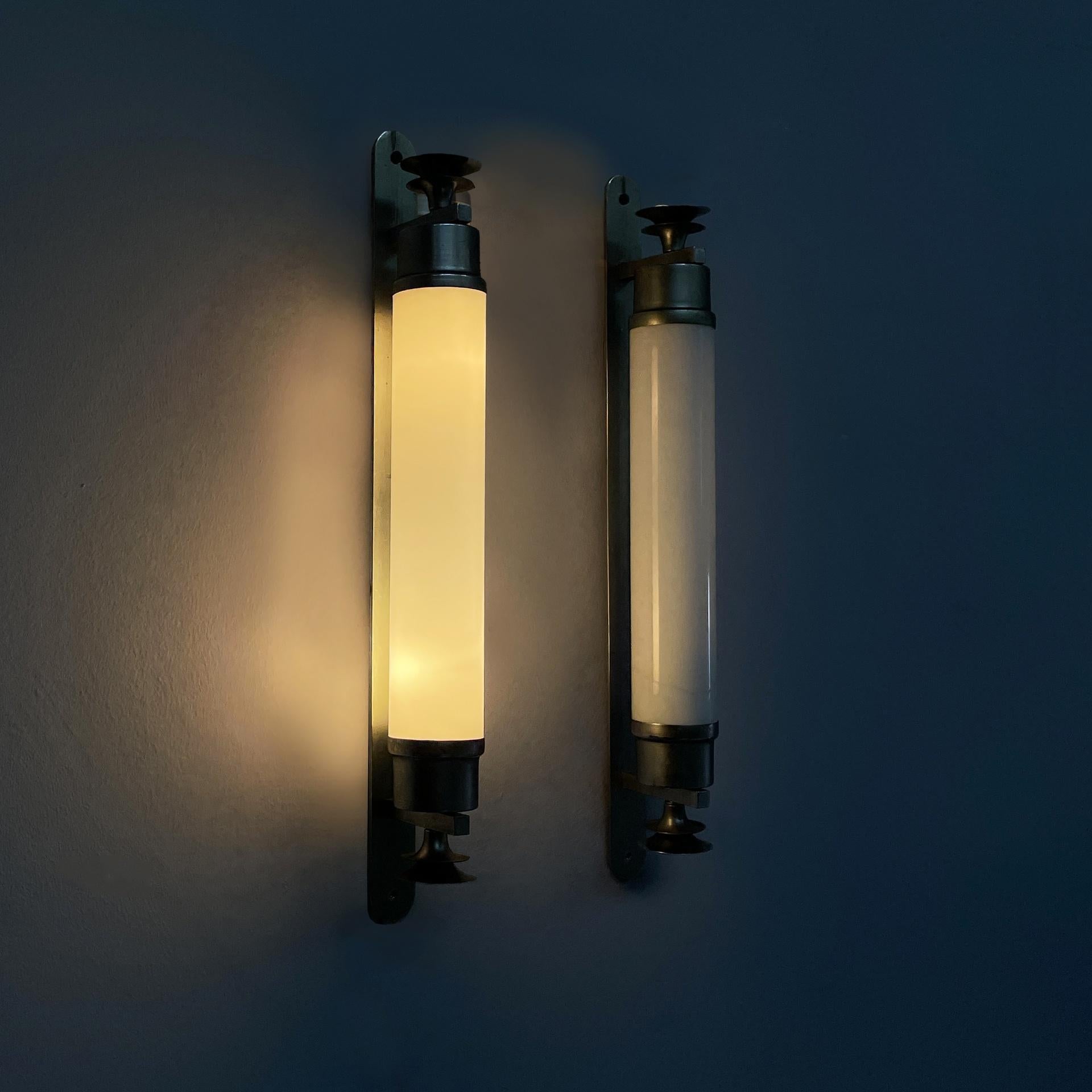 Italian Art Deco cylindrical wall lamps in opaline glass and metal, 1930s
Pair of wall lamps with cylindrical diffuser in opaline glass with metal ends. Inside there are two E27 bulbs. At the ends there are metal decorations. Two horizontal strips