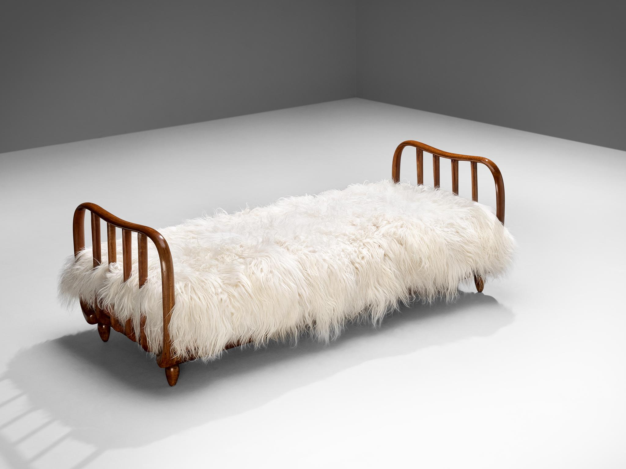 Daybed or bed, walnut, sheepskin, Italy, 1940s

This daybed alludes to the stylistics traits of the artistic Art Deco movement of the 1940s. The whole unit feels unified and simplistic by means of the curved shapes and round edges of the borders and