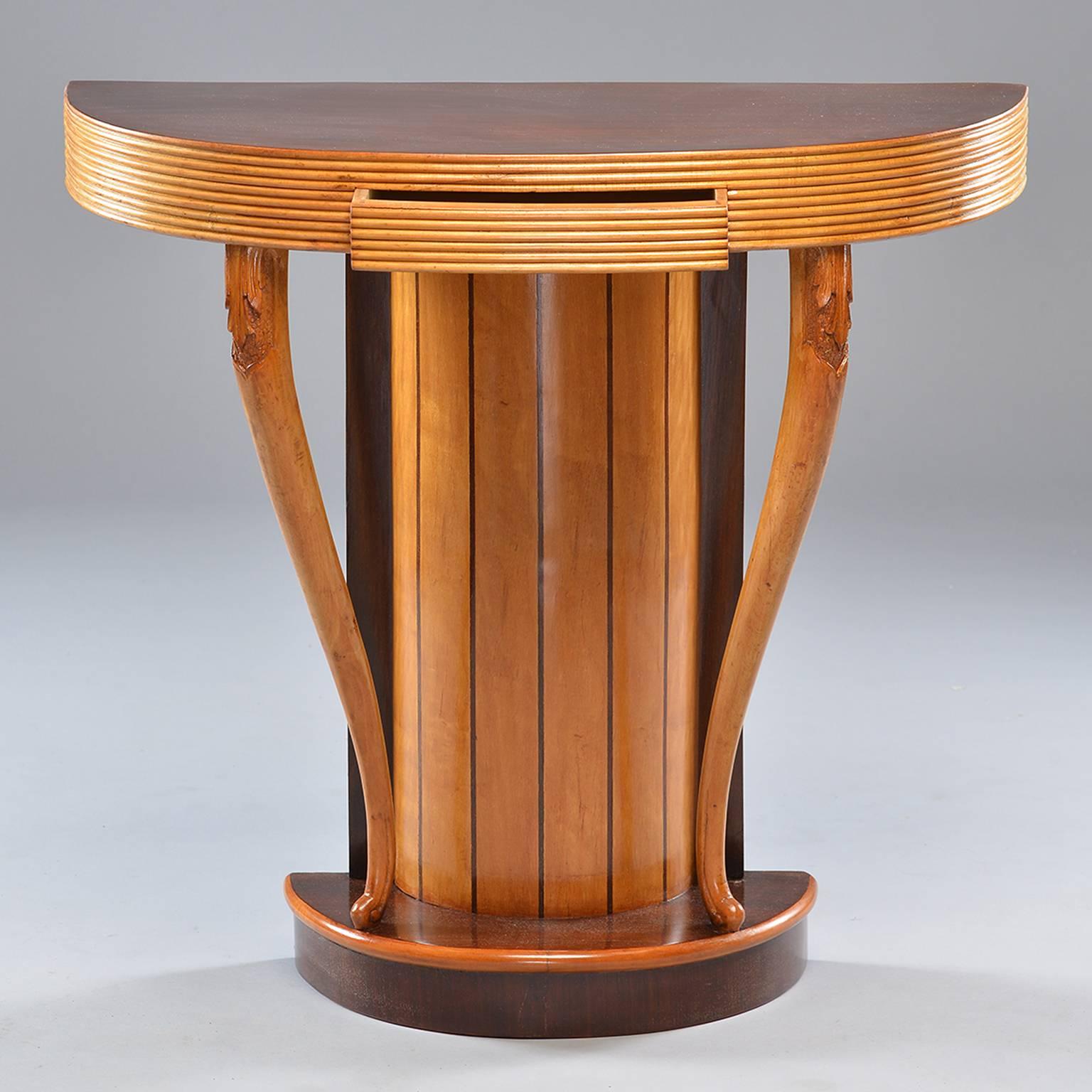 Unusual Art Deco era console found in Italy. Demilune wood top with stacked, reeded apron and pedestal base supported by two cabriole legs with carved foliate detail and contrasting dark wood tabletop and base trim. Single narrow center drawer.