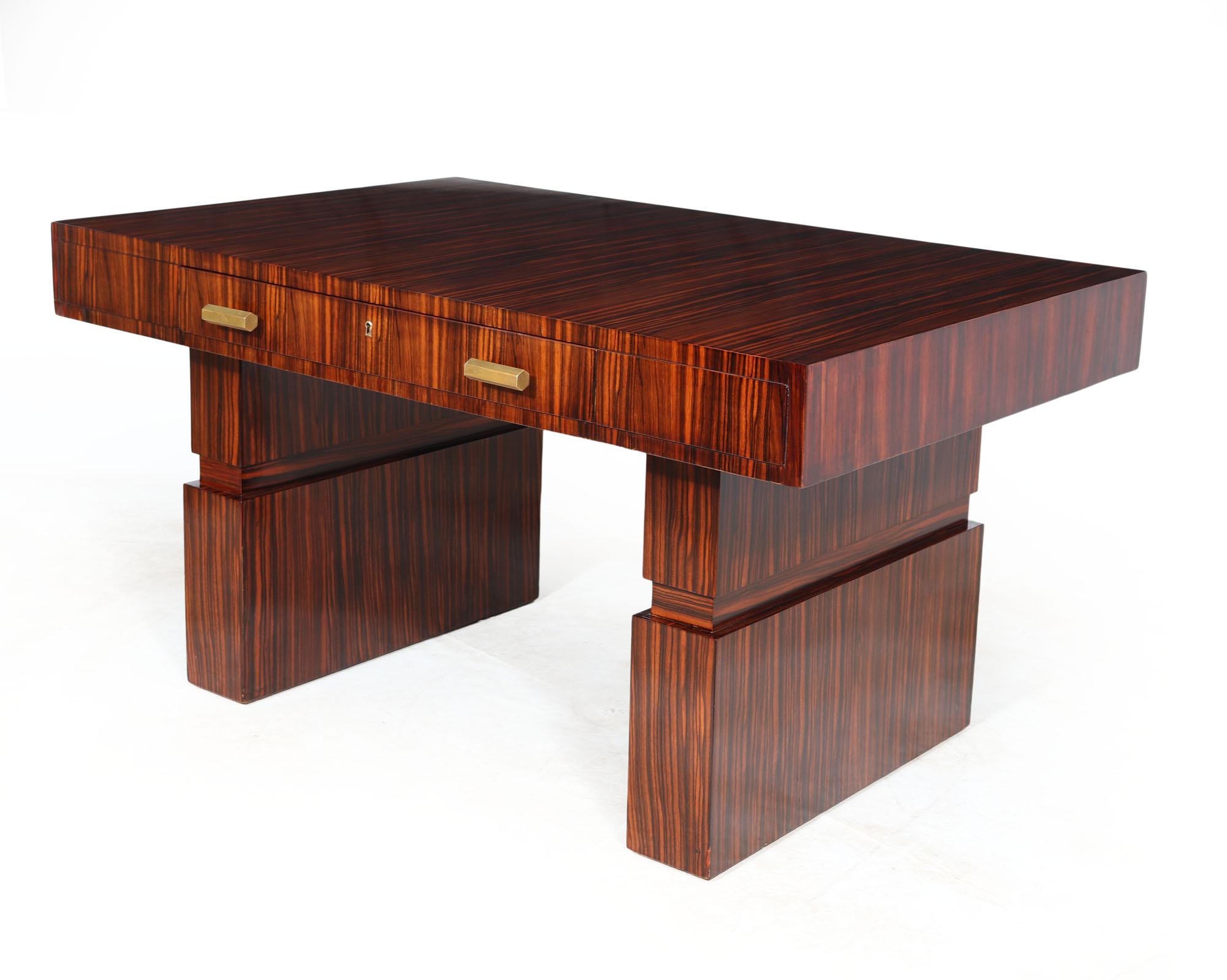 ITALIAN ART DECO DESK 
A 1930’s Italian Art Deco writing desk of very stylish design produced in Macassar ebony with brass handles, good size top with single central drawer with inset lock and working key drawer standing on twin pedestal columns,