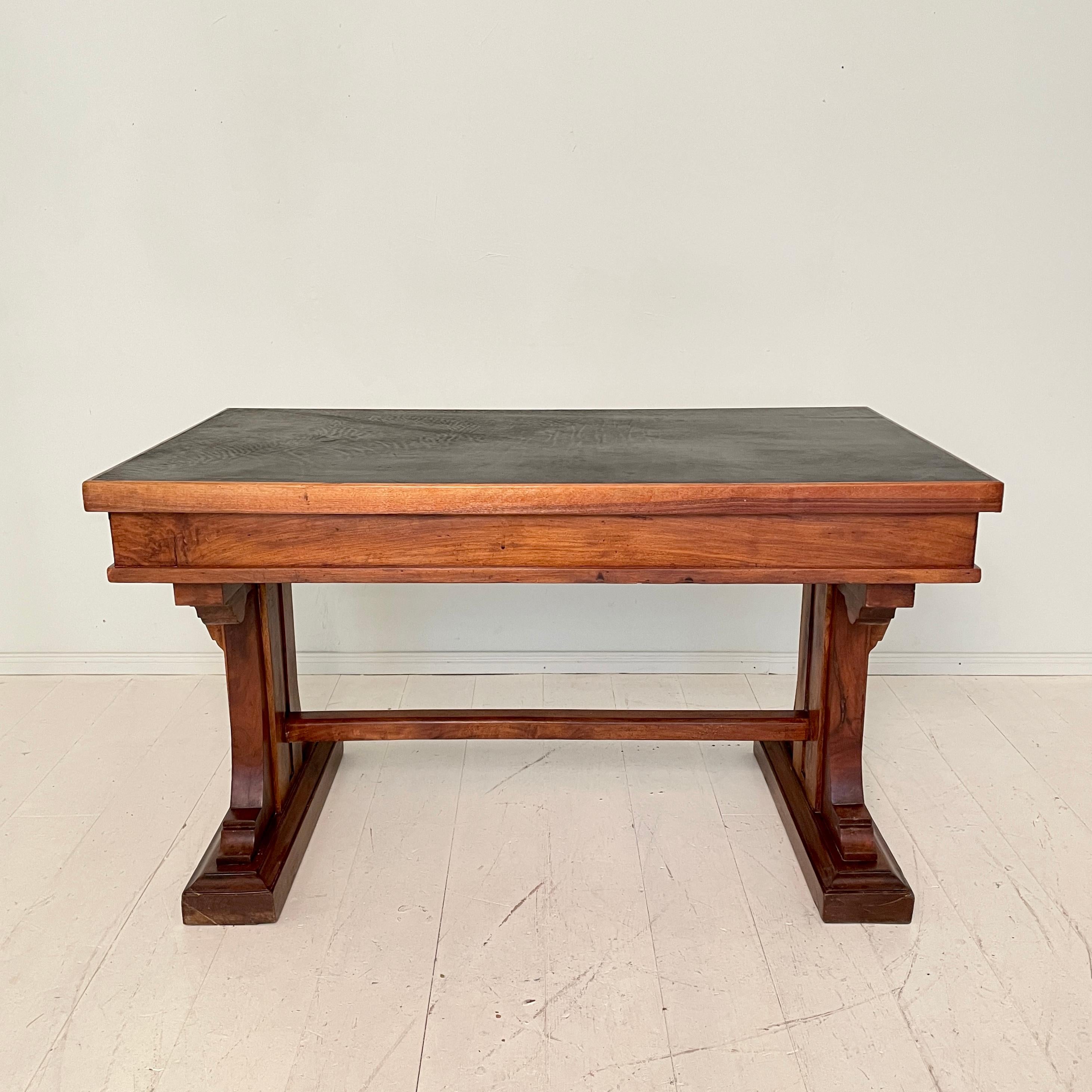 This beautiful eclectic Italian Art Deco desk or writing table was made in the 1920s.
It is make out of solid walnut and pine. The top is made out of black leather.
It is a mix out of Gothic, Renaissance and a could also come out of a