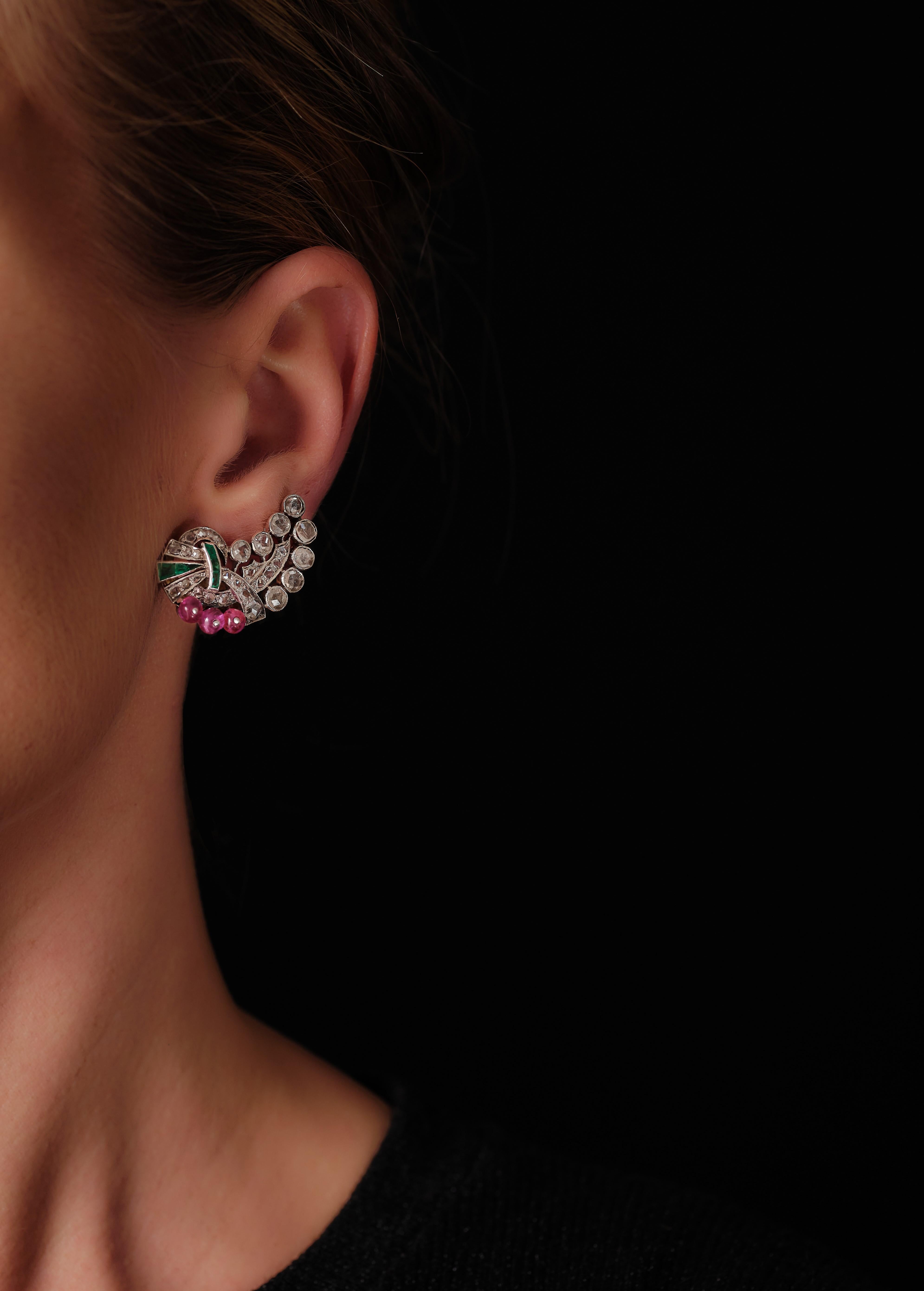 Big, a bit whimsical, rather naïve and utterly charming Italian earrings are all that! Elegant scrolls embellished with calibré cut emeralds, rose and single cut diamonds and three ruby beads each. 18 karat gold and silver with a pin and clip