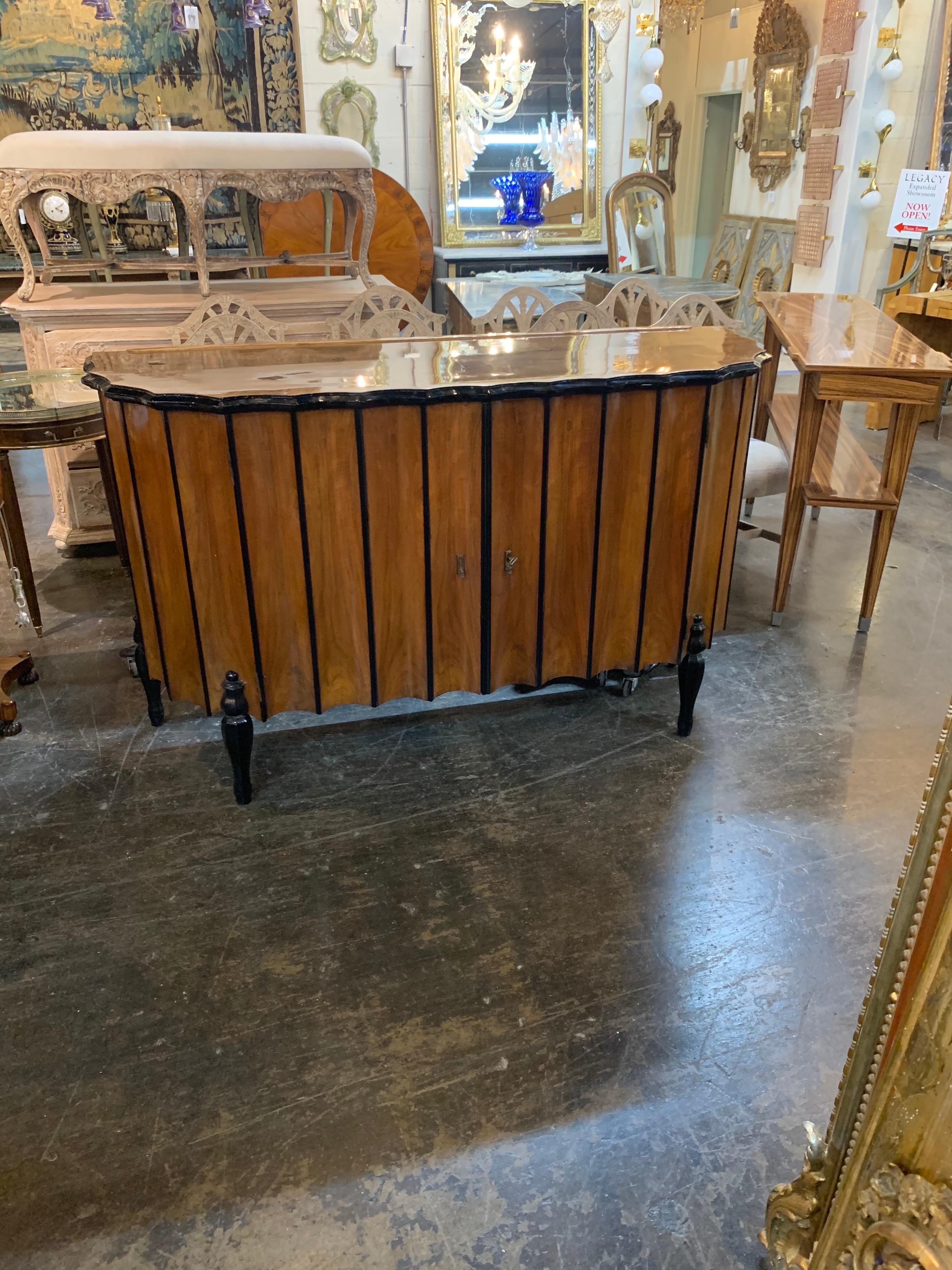 Decorative Italian Art Deco style elmwood buffet with ebonized details. Very fine wood with a beautiful finish and nice scalloped pattern on the doors. Totally unique!
Nice storage as well.