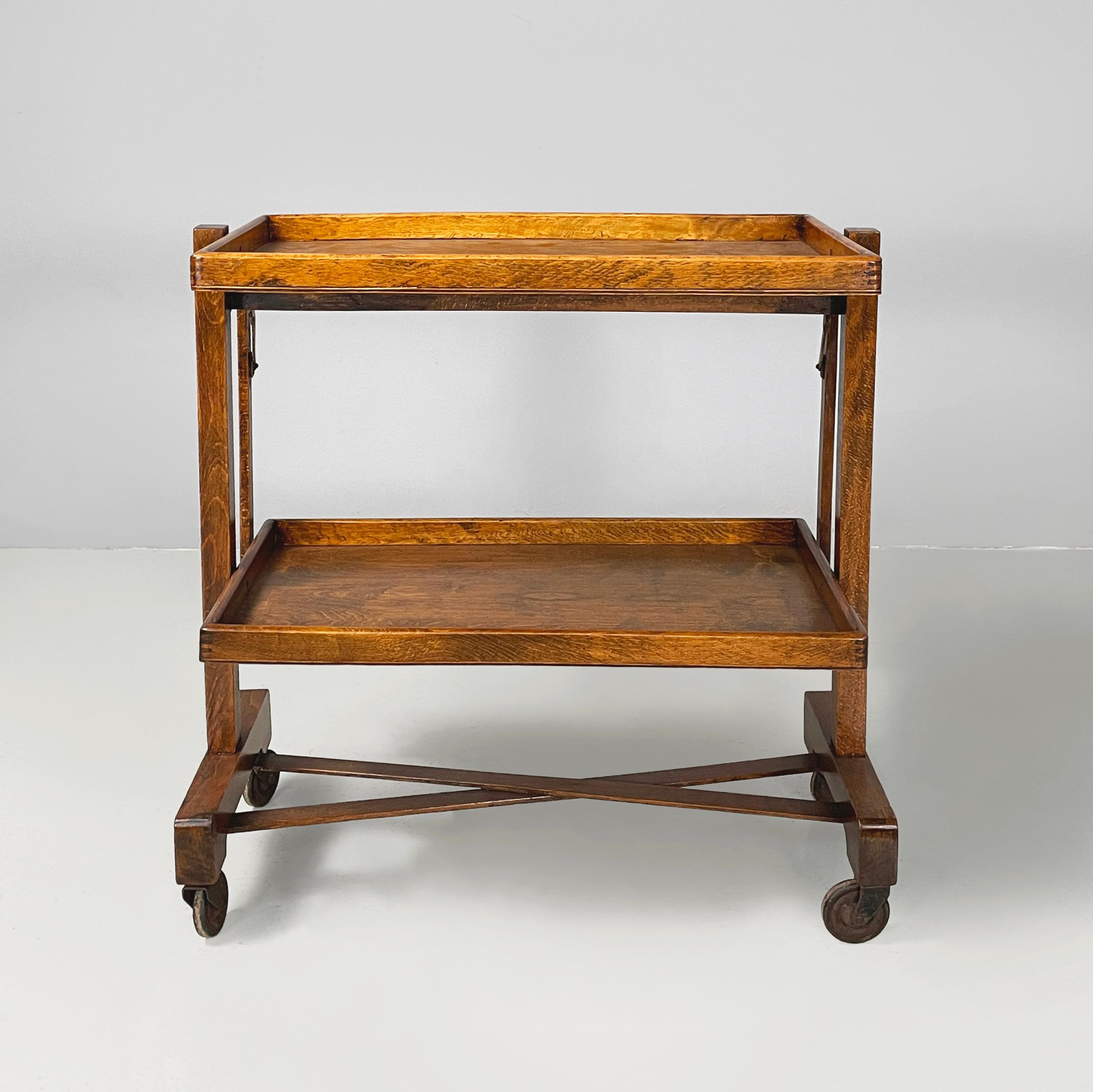 Italienischer Art-Deco-Klappwagen mit 2 Regalen aus Holz, 1930er Jahre
Wagen mit doppelten rechteckigen Regalen, ganz aus Holz. Jedes Regal hat einen erhöhten Rand. Die Beine, die in der Mitte durch zwei X-förmige Streifen verbunden sind, haben