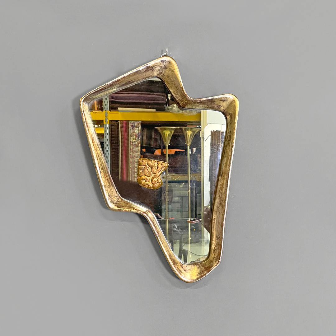 Italian Art Deco golden wood wall mirror with abstract curved structure, 1940s
Wall mirror with golden and silver wooden frame. The structure has an abstract, curved and rounded rectangular shape, with raised edges. On the mirror there is a square