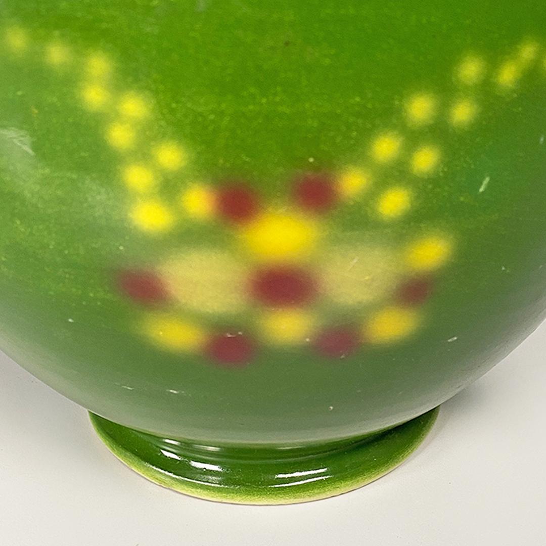 Italienische Vase aus grüner Keramik mit kreisförmigem Motiv von Deruda, Art déco, ca. 1940
Keramikvase im Art-déco-Stil mit grünem Hintergrund, mit Mustern in Gelbtönen und dekorativen Knopflöchern mit kreisförmigem Motiv, sehr elegant und