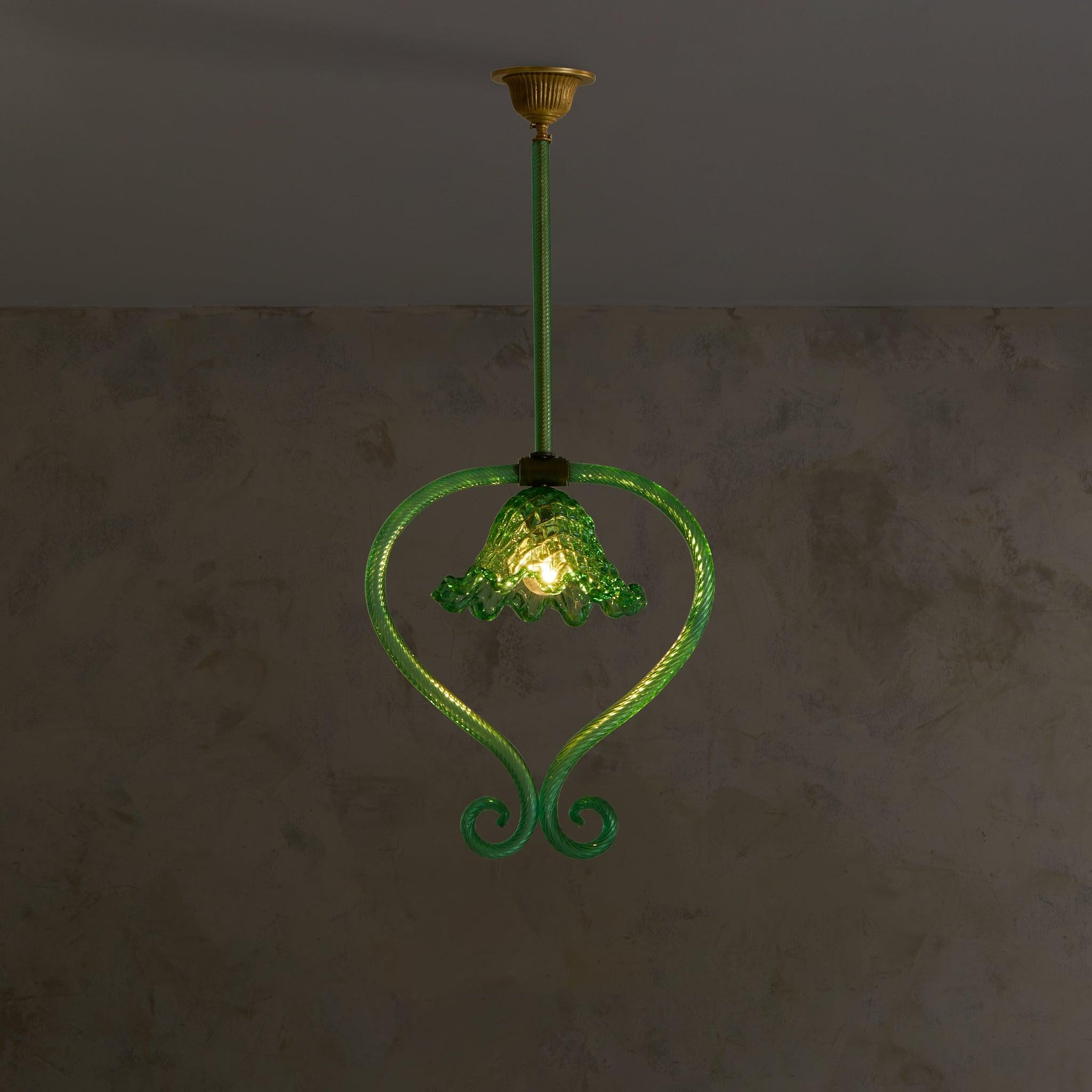 Raro colgante Art Déco de cristal de Murano atribuido al apreciado atelier Barovier & Toso en la década de 1930. El vívido cristal verde esmeralda está soplado a mano con maestría en una pantalla delicadamente acanalada y con volantes, suspendida