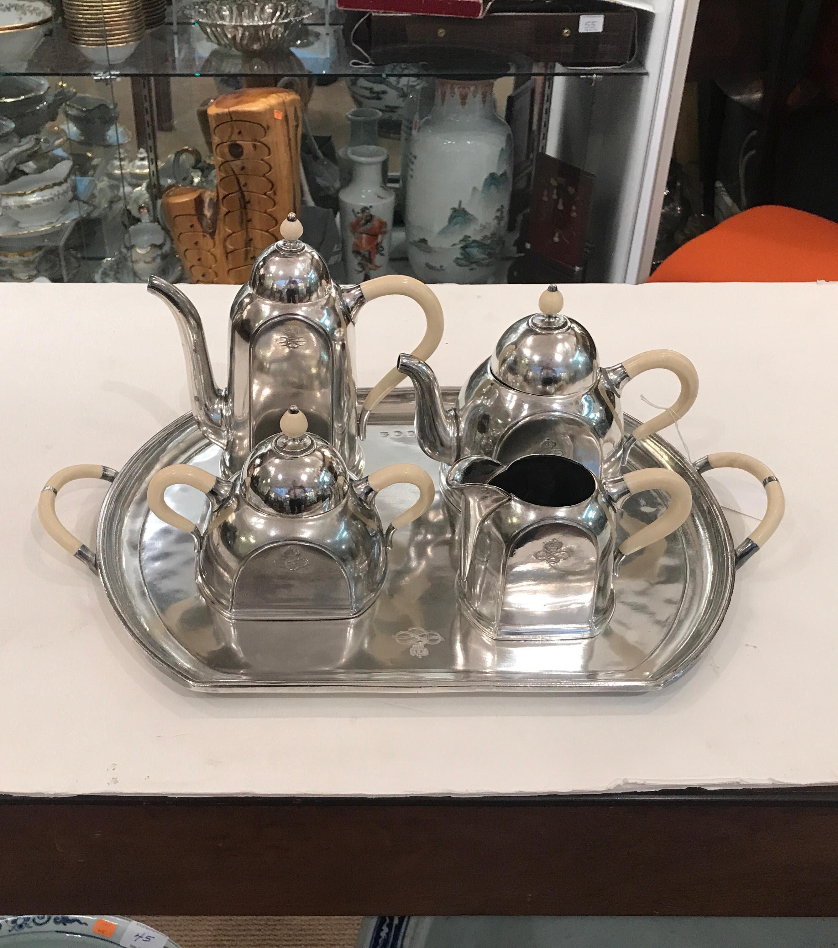 An elegant hotel silver plate Art Deco five piece tea and coffee set. The set consists of original tray, coffee pot, tea post, covered sugar, and creamer. The deco design which has broad flat bottoms to prevent spilling and tipping for use on an