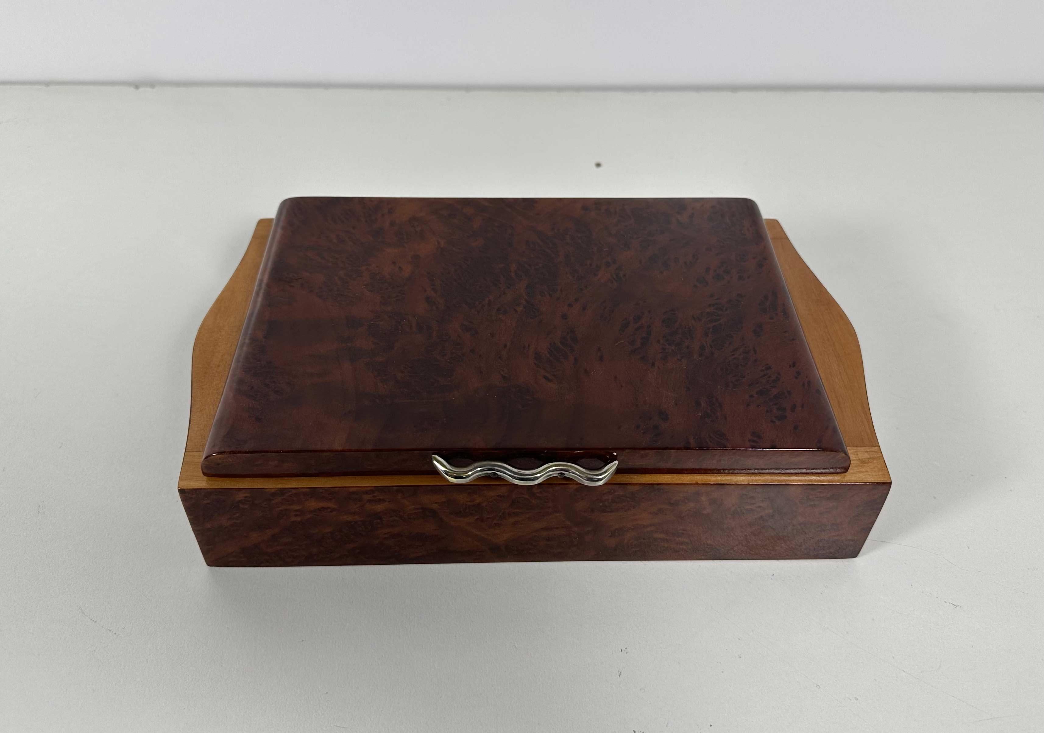Cette boîte à bijoux Art déco est un véritable bijou et a été produite en Italie dans les années 1930. 
Il est entièrement fabriqué en bois de myrte, avec une poignée en laiton. 
Il a été restauré. 