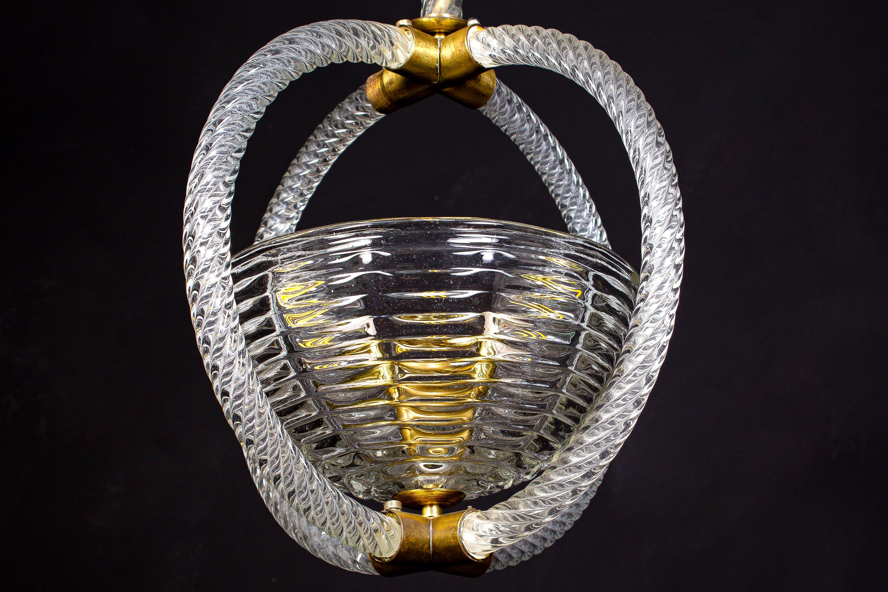 Elegant Art Deco pendant centered by a precious Murano hand blown glass cup.
Brass-mounted with original warm natural patina. One E27 lamp socket.
The chain can be shortened on request.
Perfect vintage condition.
 