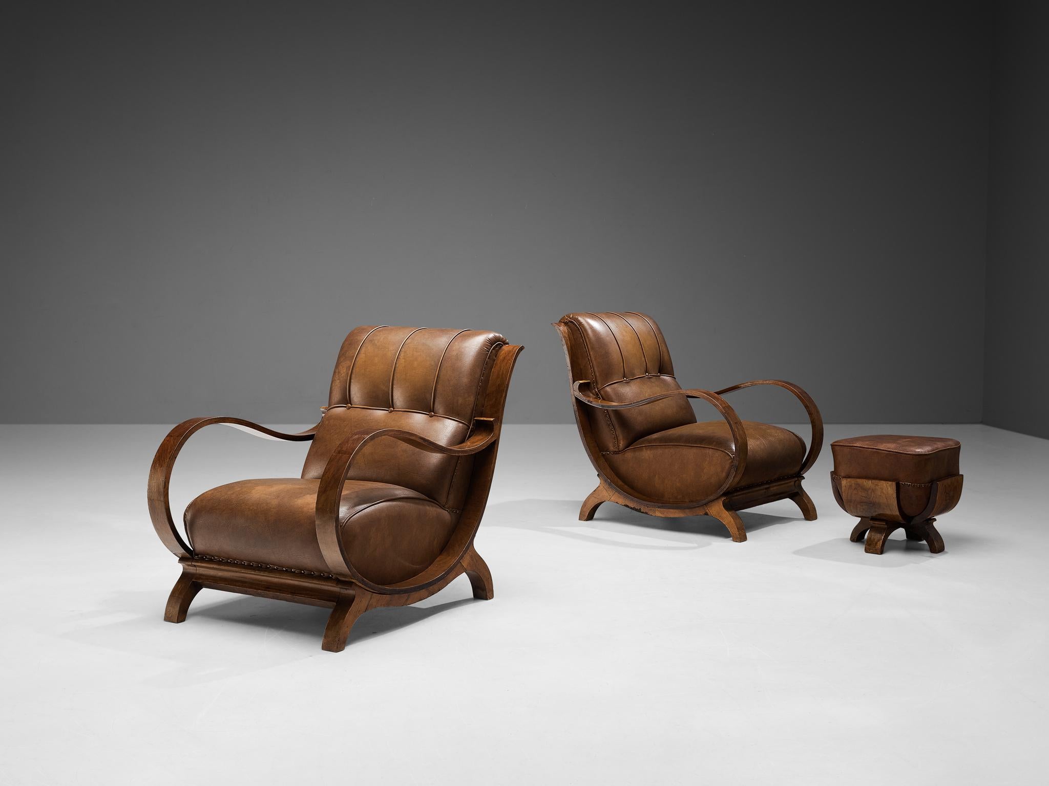 Pair of lounge chairs and ottoman, leather, walnut, metal, Italy, 1930s

Special and attractive pair of Italian lounge chairs and one ottoman. The wood used to form the beautiful curves and lines of this design is walnut. The leather is cognac