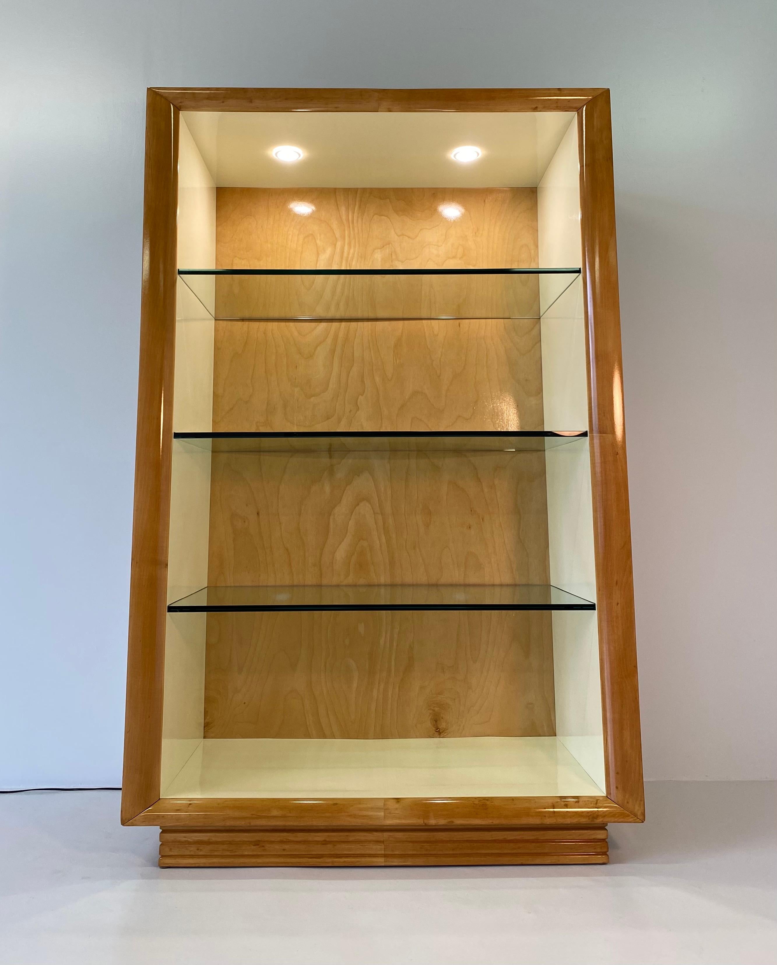 This bookcase or cabinet for sculptures was produced in the 1940s
in Italy and is entirely covered in fine maple wood.
The internal part is in ivory lacquer with three glass shelves.
The compartment is illuminated with two spotlights which create
