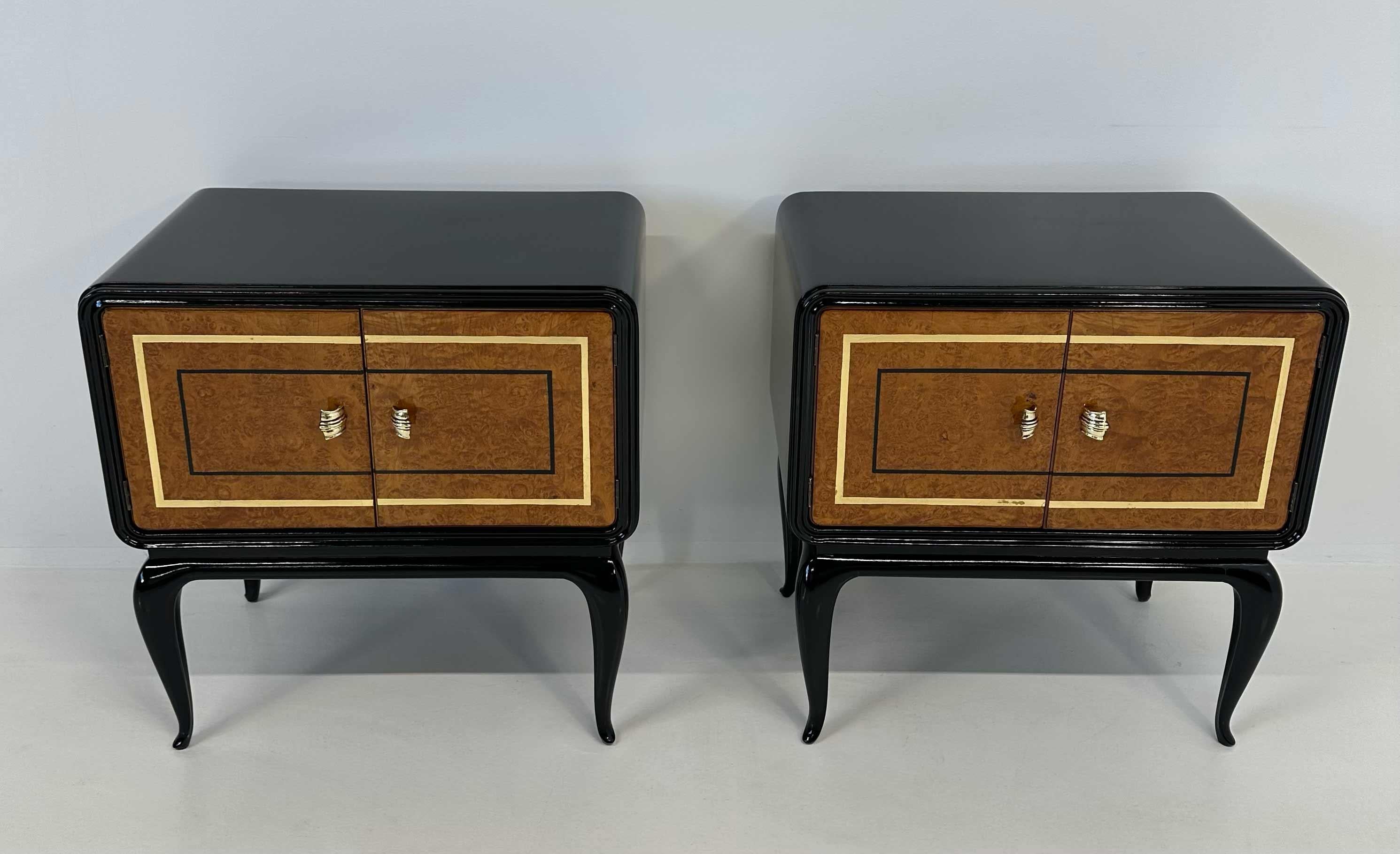 This pair of Art Deco nightstands was produced in Italy in the 1940s. The structure is completely in black lacquered,  while the doors are in maple briar. The doors have a gold leaf decoration.
The handles are in brass. 
They have been completely