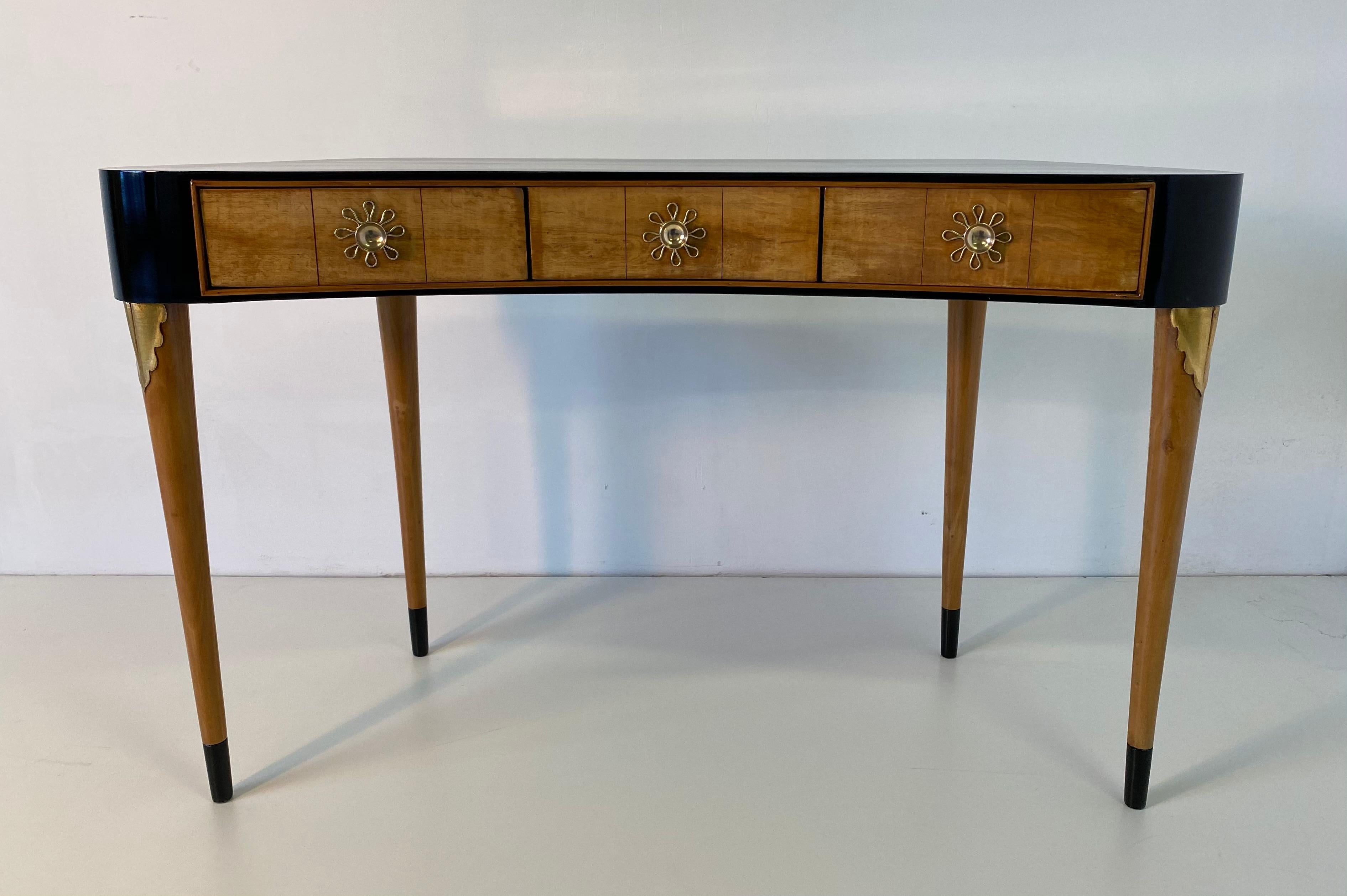 This small desk was produced in the 1940s in Italy, the legs are in solid maple with a carving covered in gold leaf.
The drawers are in ash while the top is black lacquered.
The precious handles are made of brass.
Completely restored.