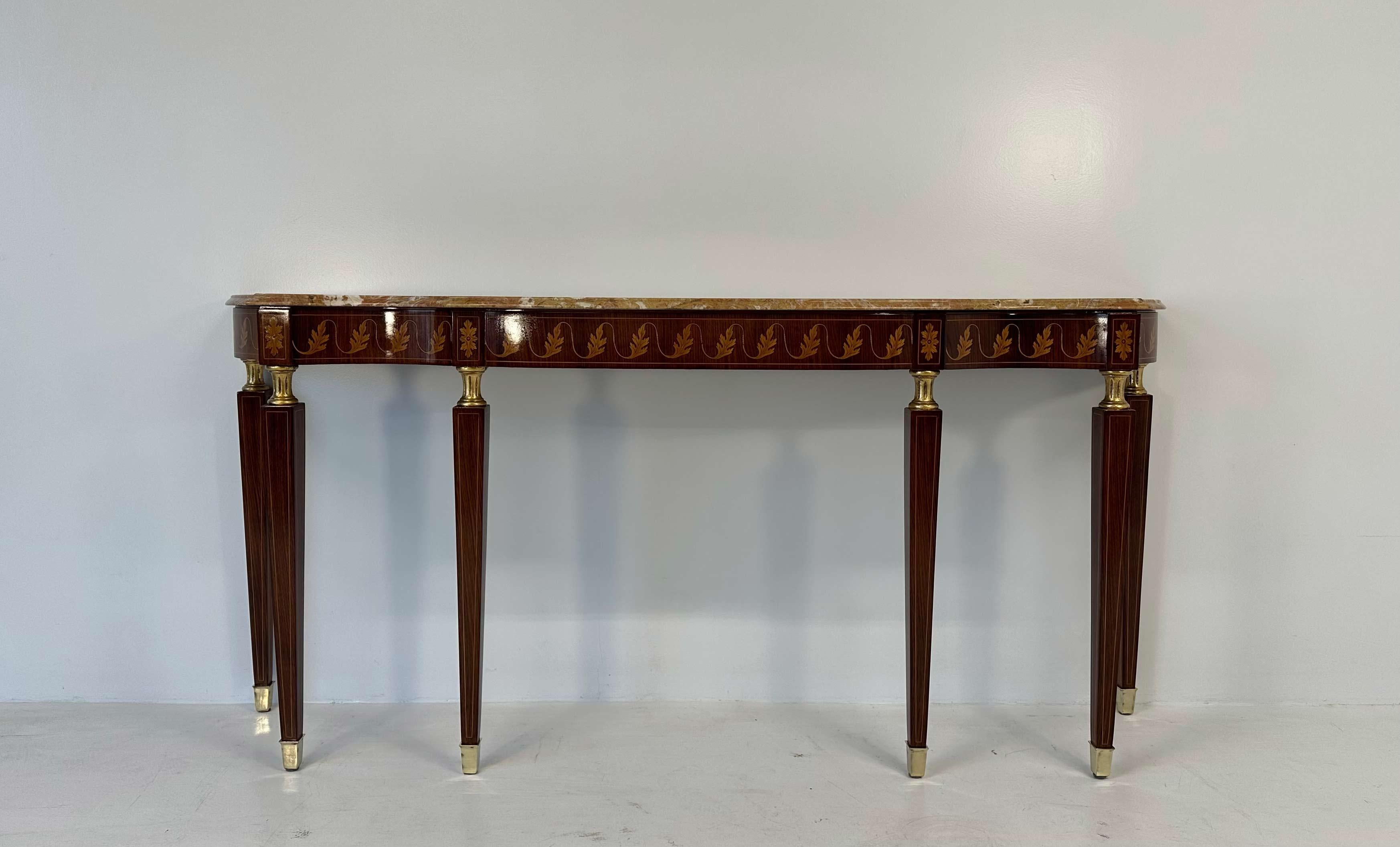 This console was produced in Italy in the 1950s and can be attributed to the design of Paolo Buffa. The top is a marble slab that lays on a structure made of precious wood, characterized by the presence of an elegant inlay depicting a classic motif