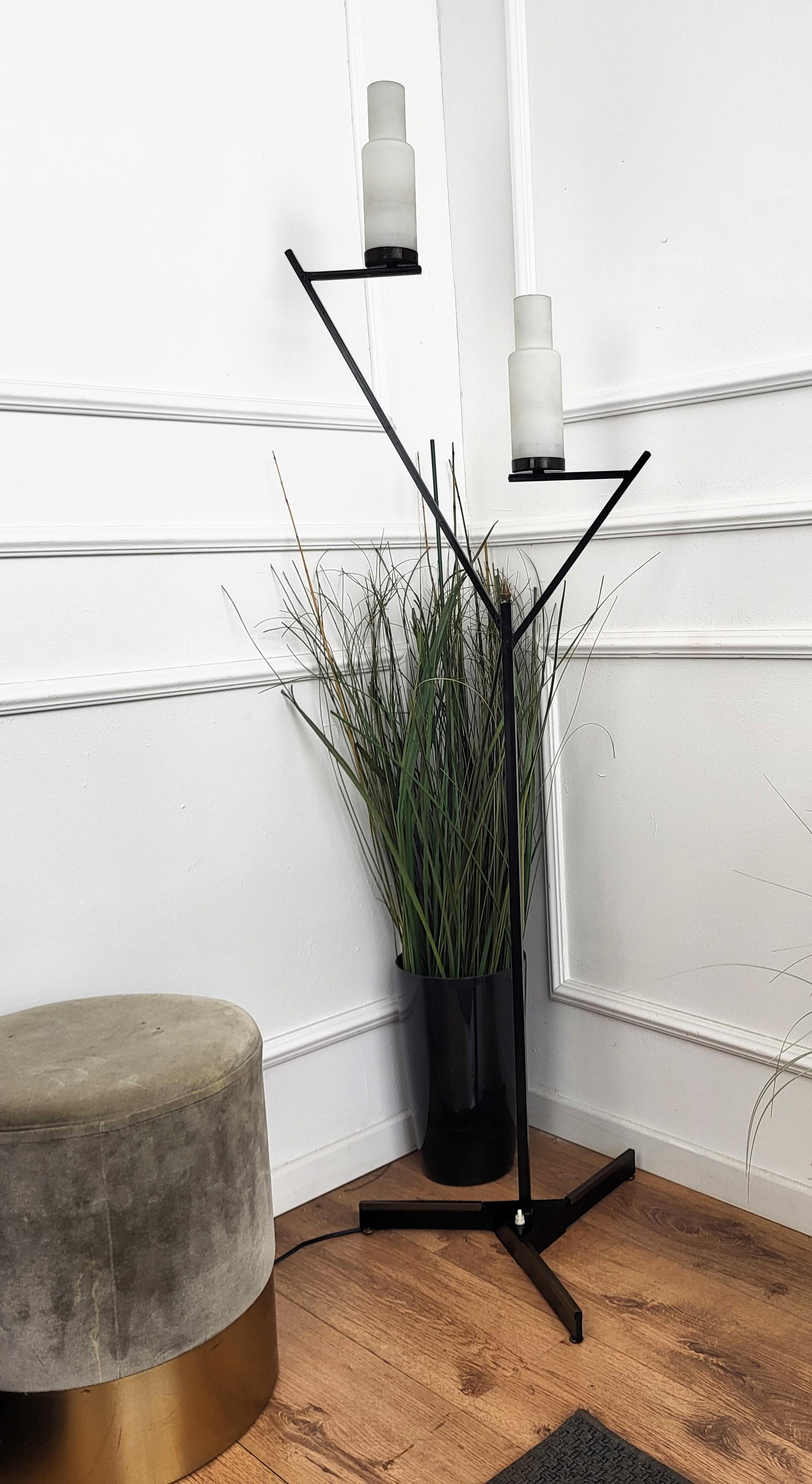 Beautiful Italian, in typical Mid-Century Art Deco style, two-armed floor lamp in black metal with brass details and opaline milk glass lampshades. Vintage lights are stylish, timeless, tasteful and classic as they remain a firm favorite to this day