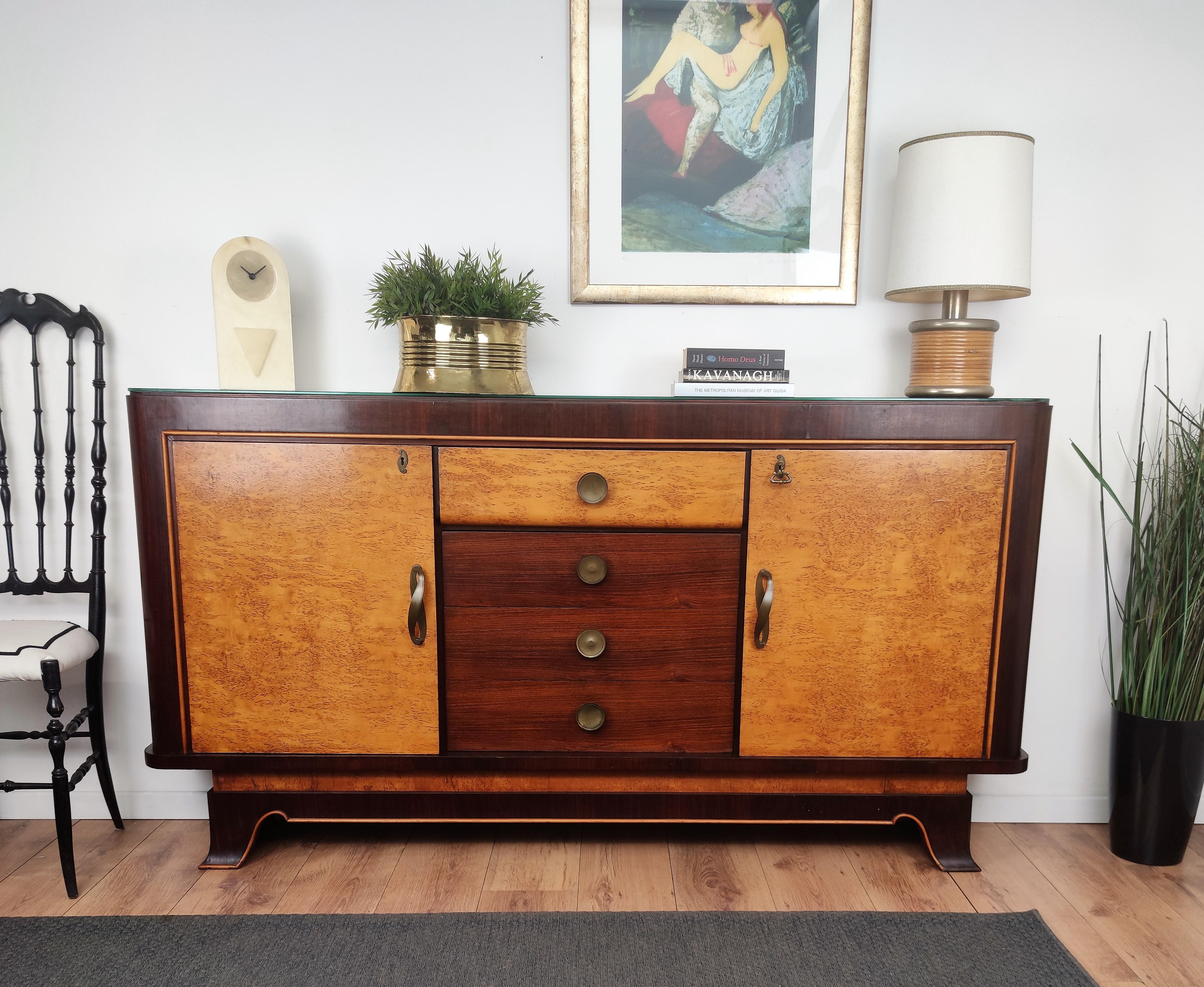 Very elegant Italian Art Deco Mid-Century Modern thin sideboard credenza or console, in beautiful veneer walnut briar burl wood, four central drawers and two side doors with shelves and great brass details, handles and keylock with black glass top.