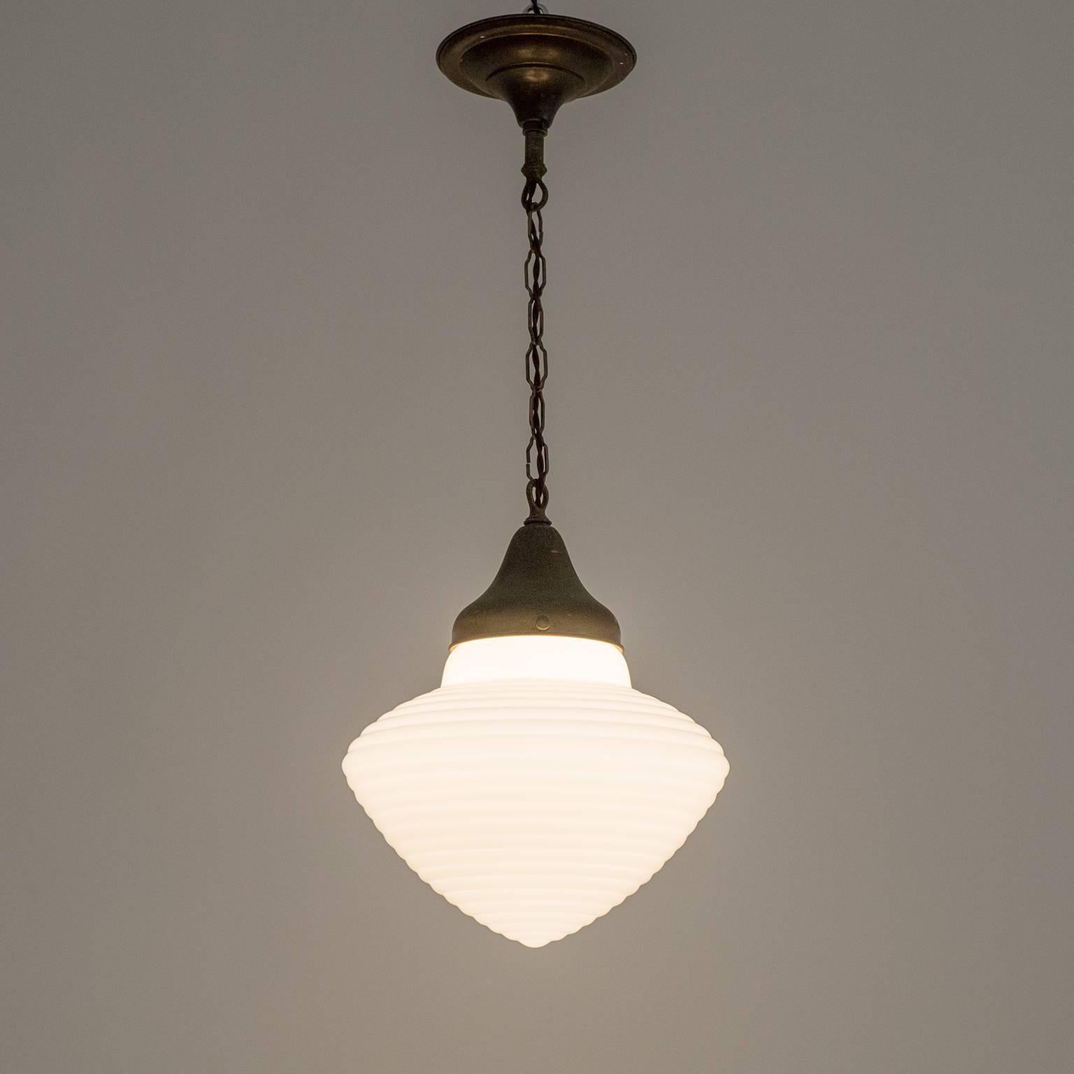 Rare Italian Art Deco industrial milk glass pendant from the 1920s. The very unusual ribbed glass body is suspended by beautifully aged brass and copper. One original brass and ceramic E27 socket with new wiring. Measure: Drop height is circa
